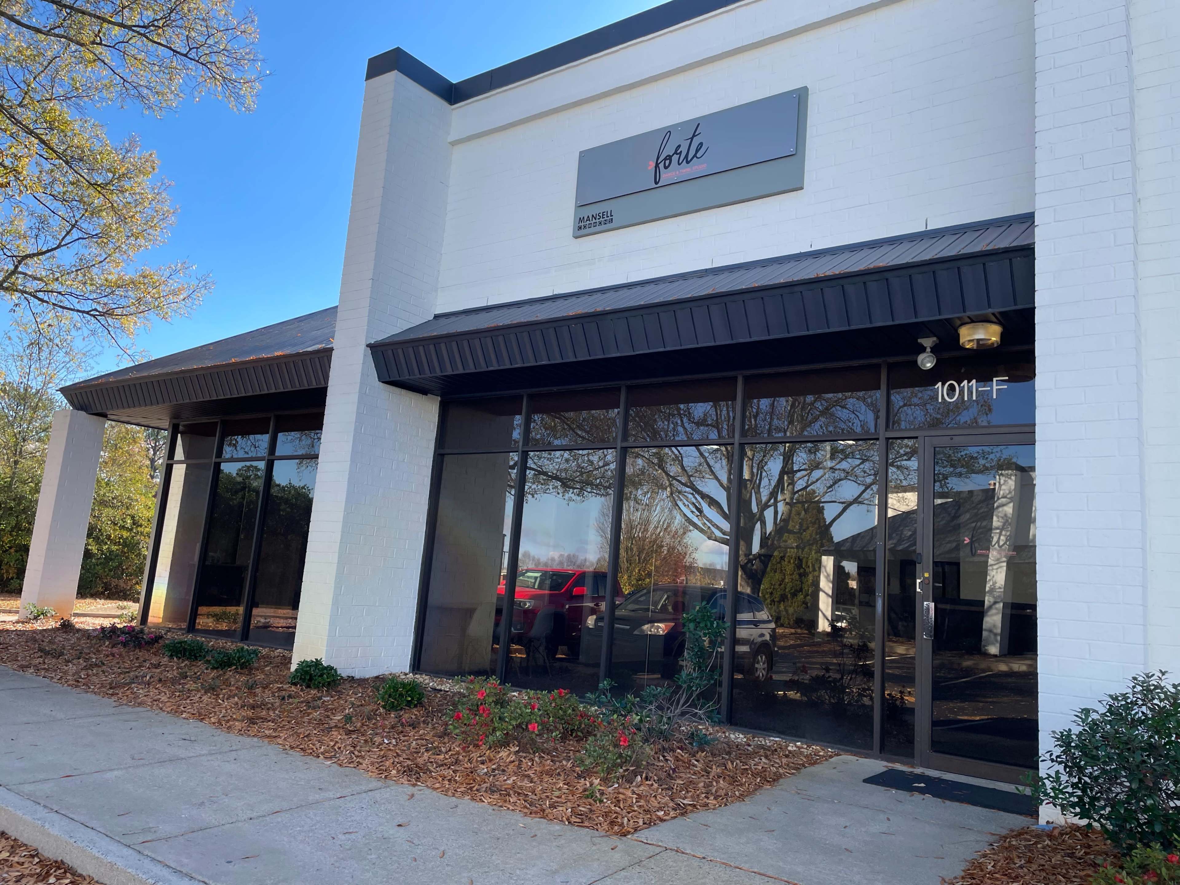 A white commercial building with large glass windows and a sign that reads "forte" above the entrance.