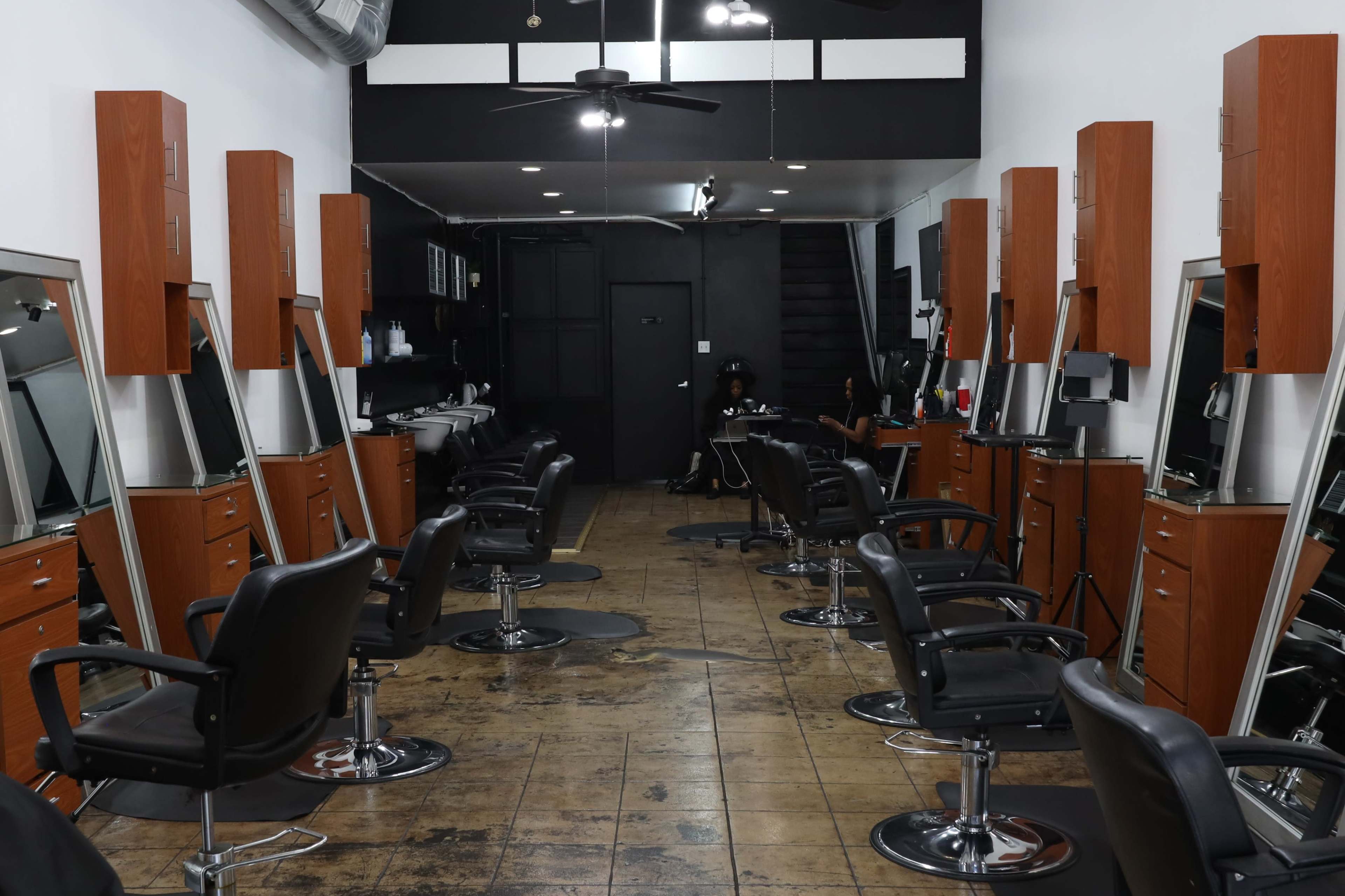A row of salon chairs with mirrors in a modern hair salon.