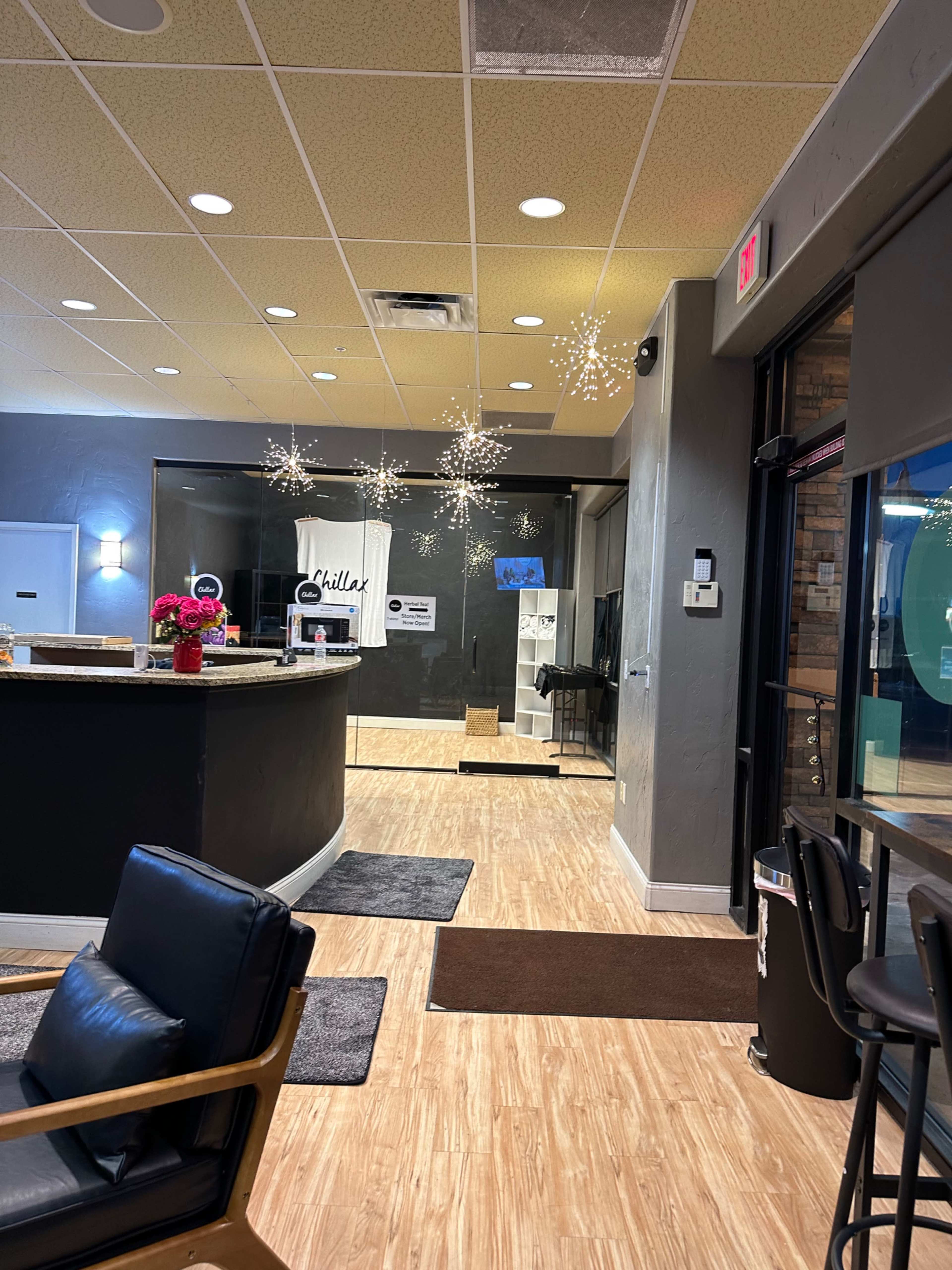 The image shows a lobby area with a reception desk, a seating arrangement, and decorative lights hanging from the ceiling.