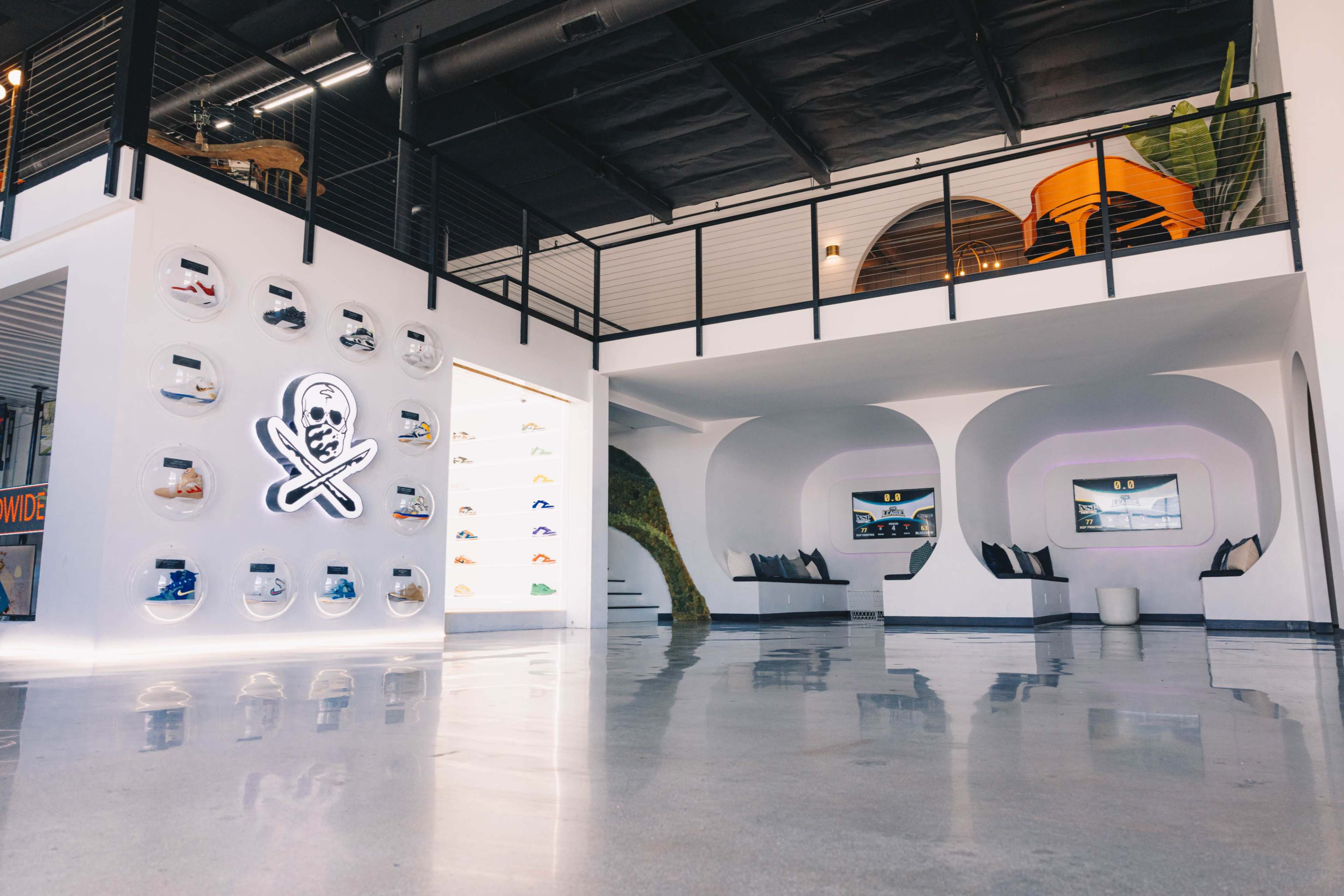 A modern retail store features a sleek interior with a footwear display on one wall and lounge seating in a spacious layout.