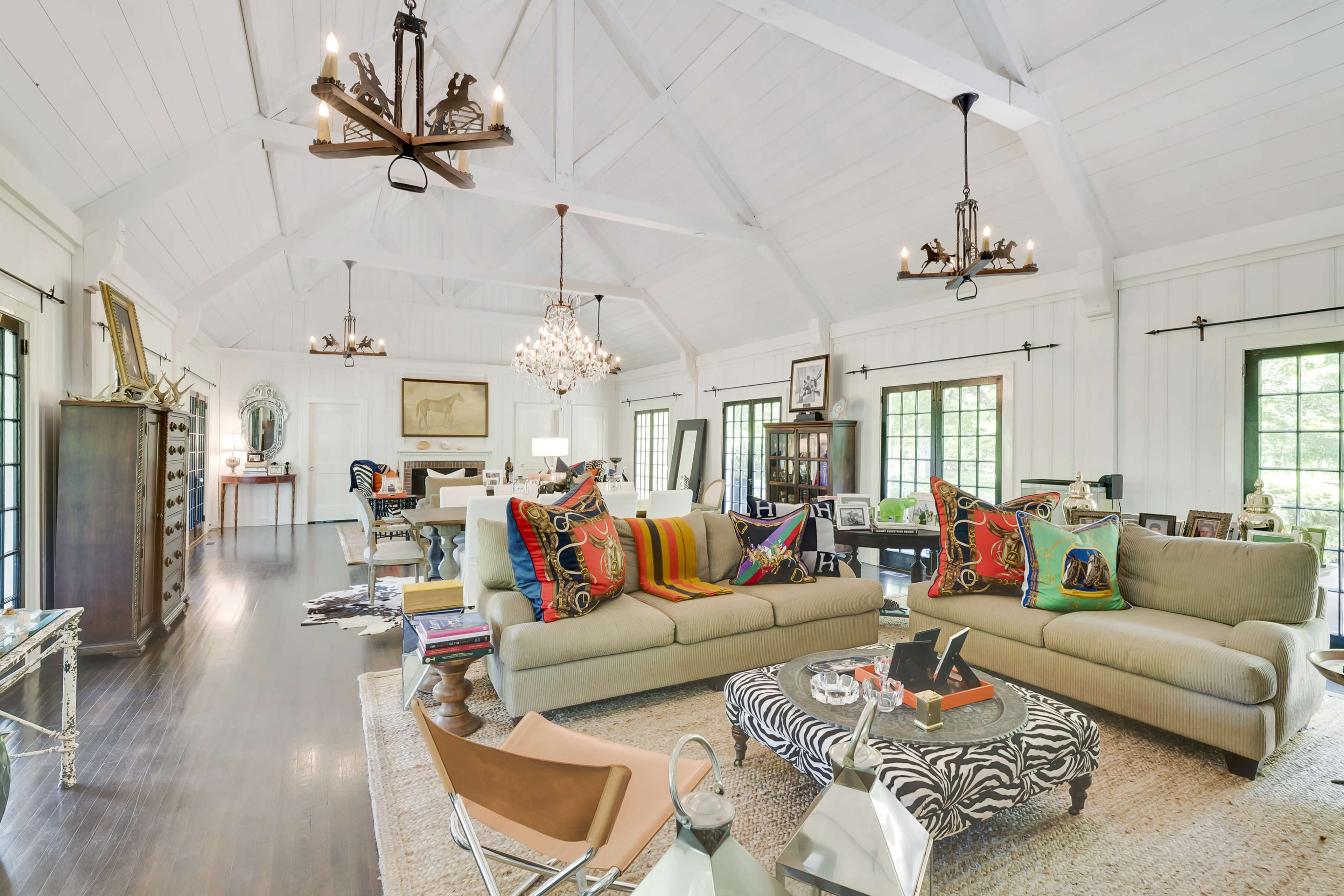 The living area features a spacious design with high ceilings, multiple seating arrangements, and a mixture of decorative lighting fixtures.