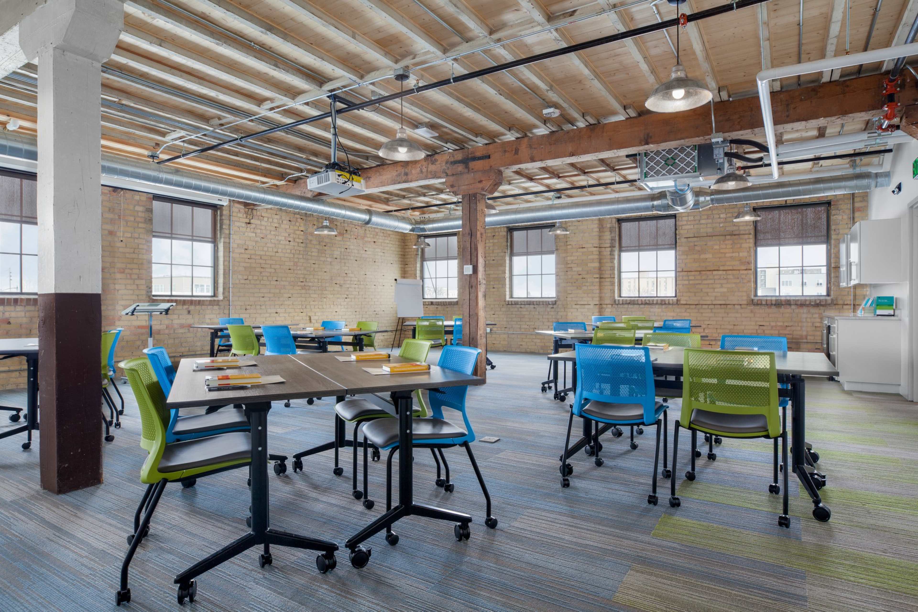 A modern classroom with flexible seating arrangements, featuring colorful chairs and tables arranged for collaborative learning.
