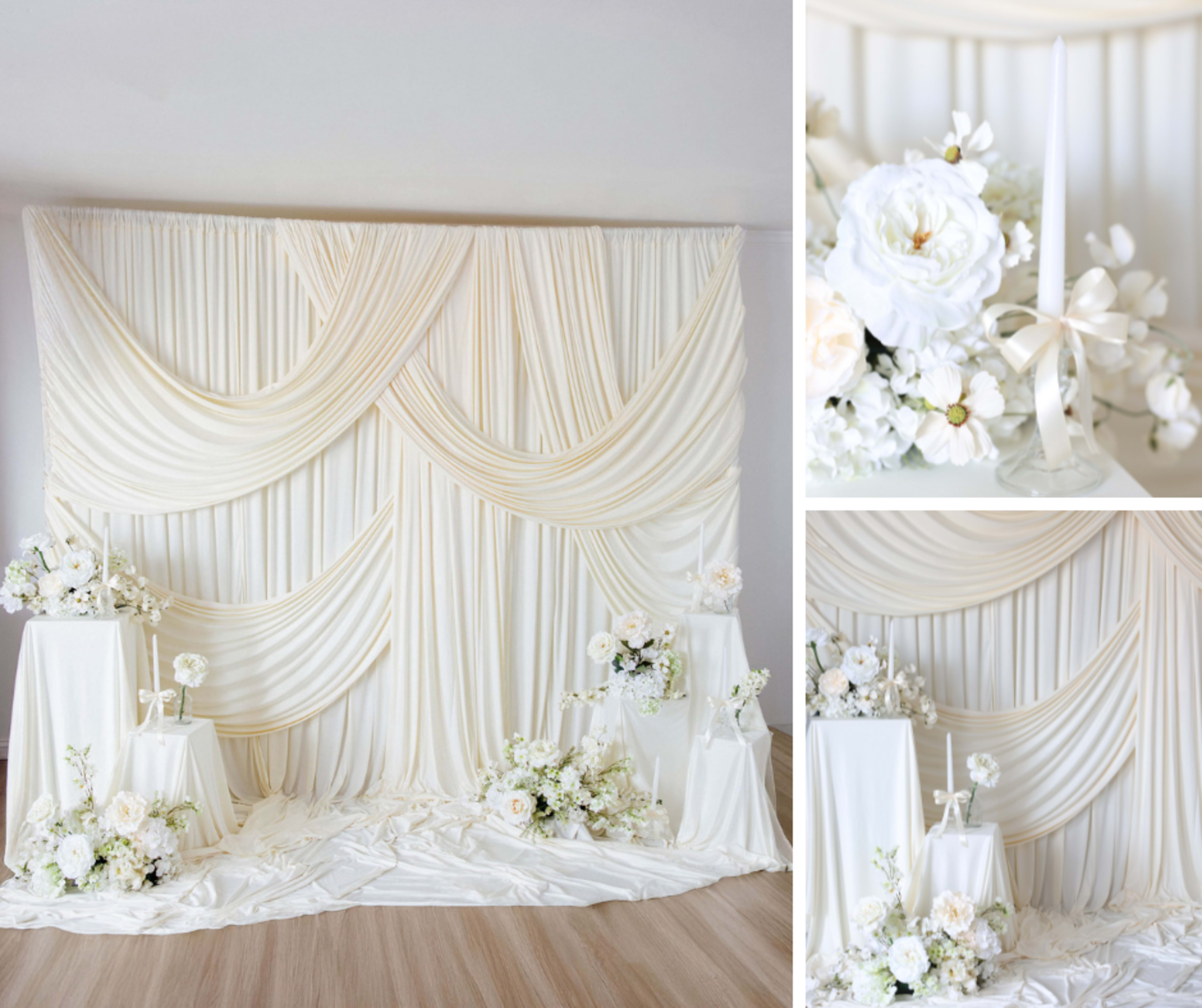 The image features a white draped backdrop with floral arrangements and candle holders placed on pedestals in a well-lit setting.