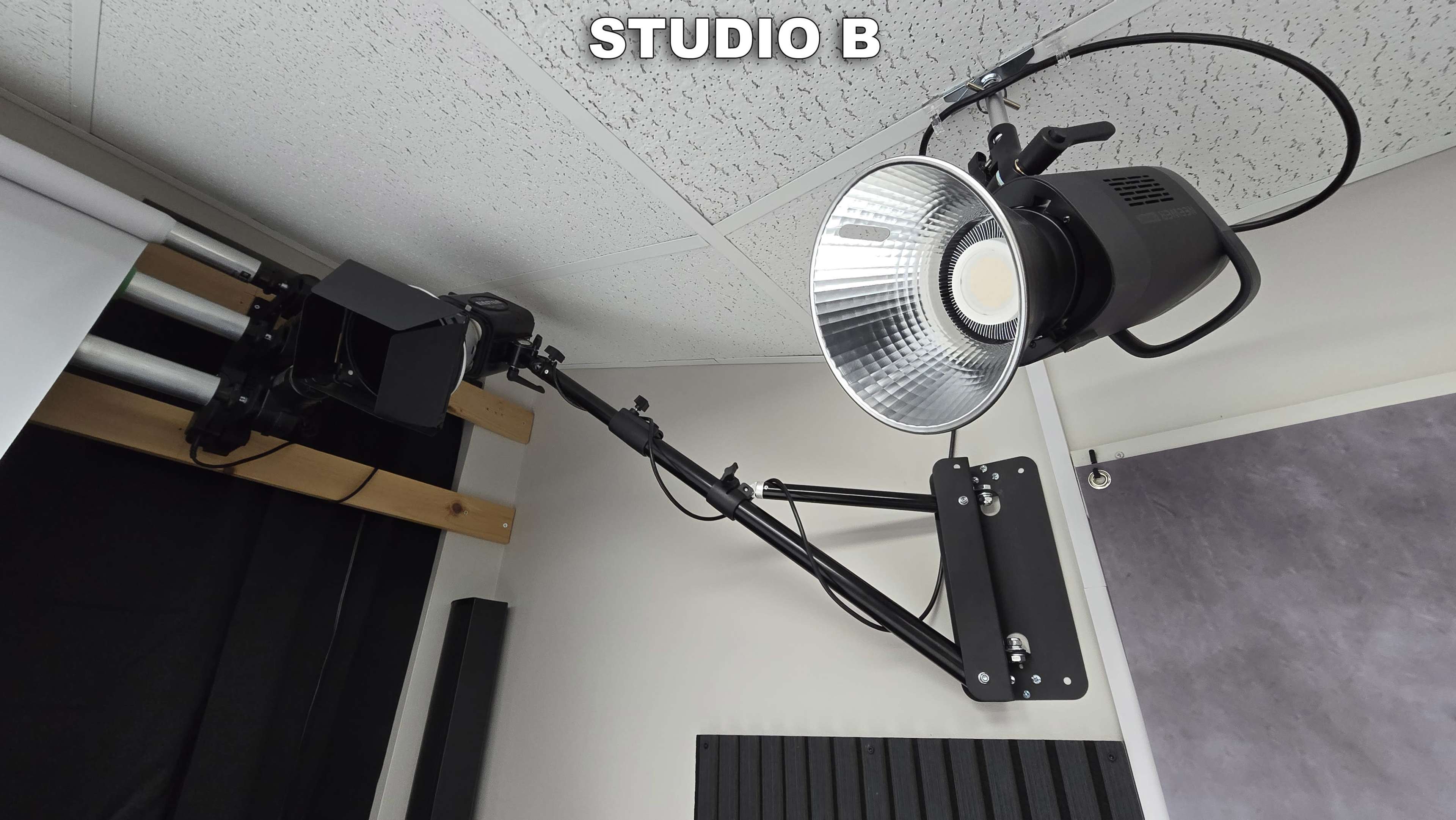 A mounted studio light fixture and camera setup in a studio labeled "STUDIO B."