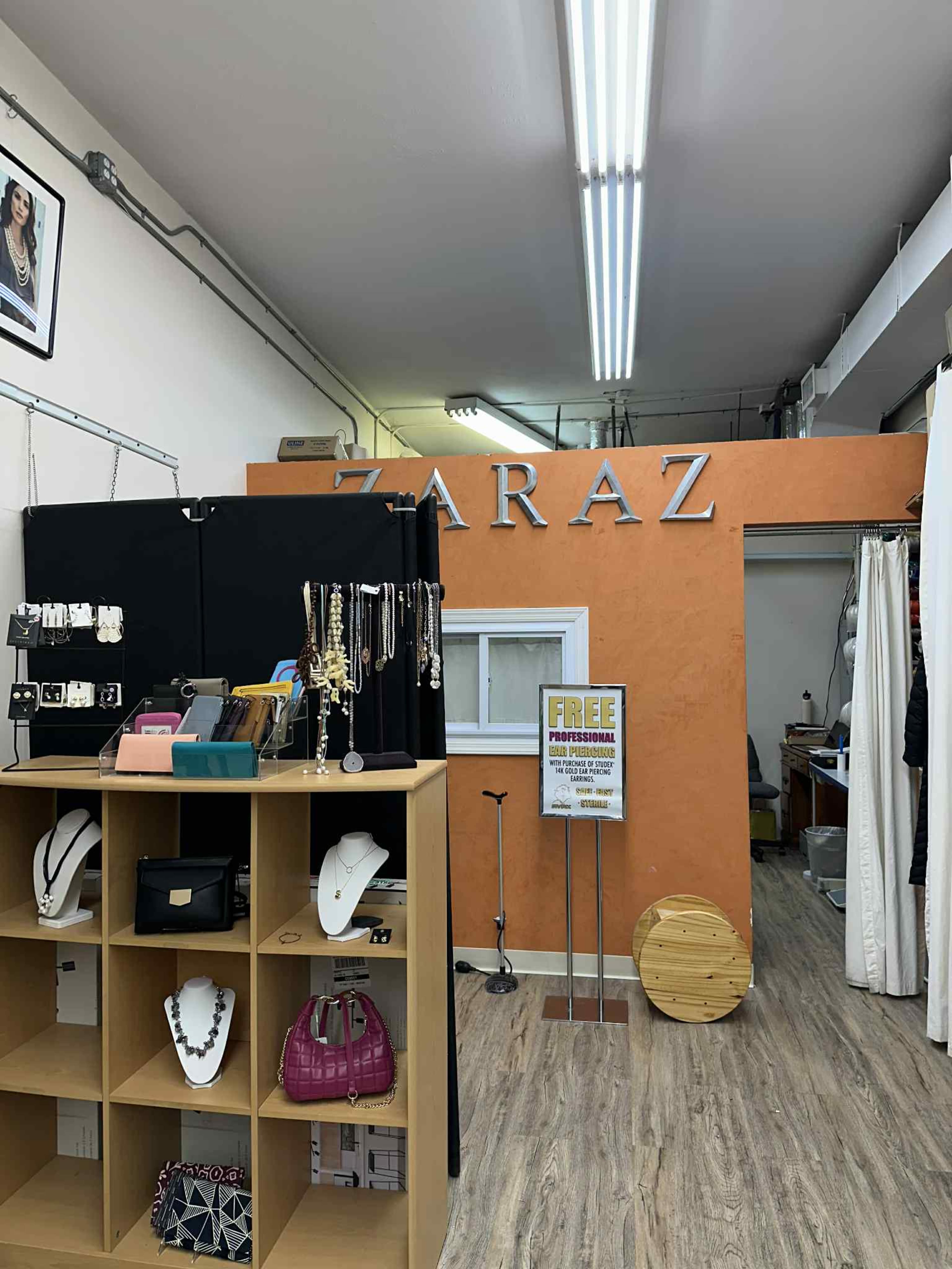 The image shows the interior of a jewelry store labeled "ZARAZ," featuring display cases with various jewelry items and a sign promoting free professional services.