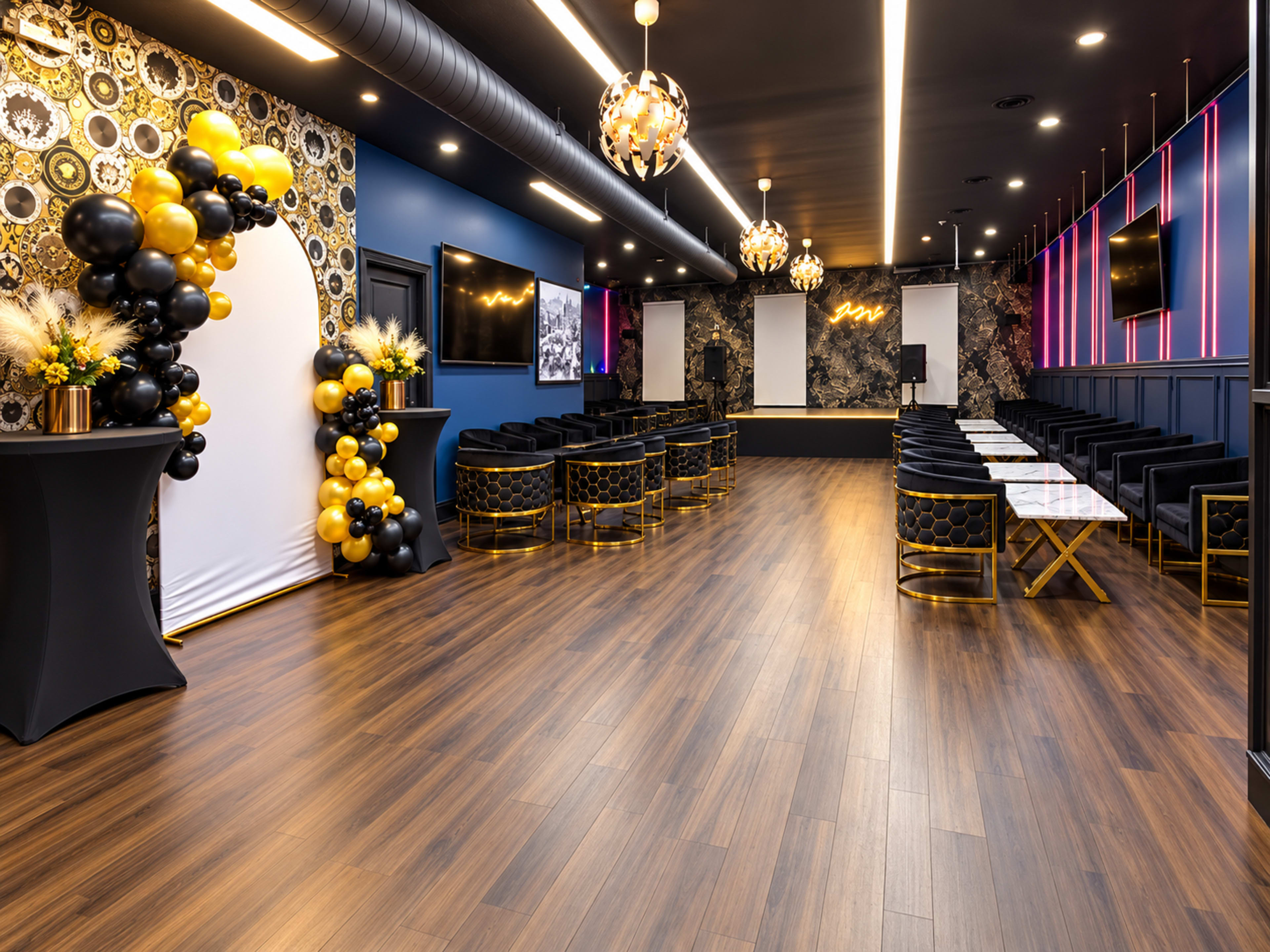 The image shows a modern event space with elegant decor, featuring seating arrangements, decorative balloons, and a stage area with lighting.