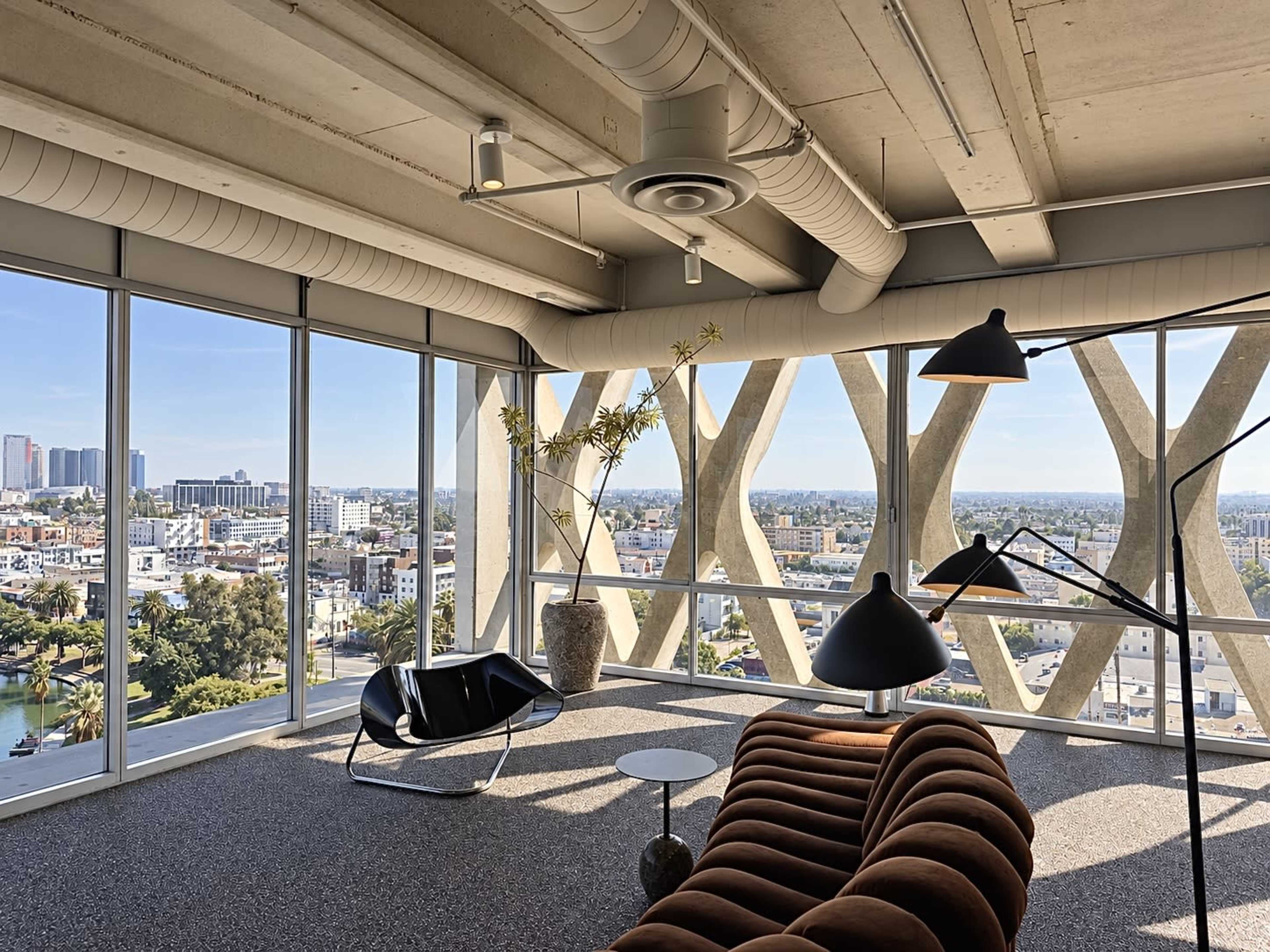 The image shows a modern interior space with a large window offering a view of a city skyline, featuring a curved brown sofa, a floor lamp, and a small coffee table.
