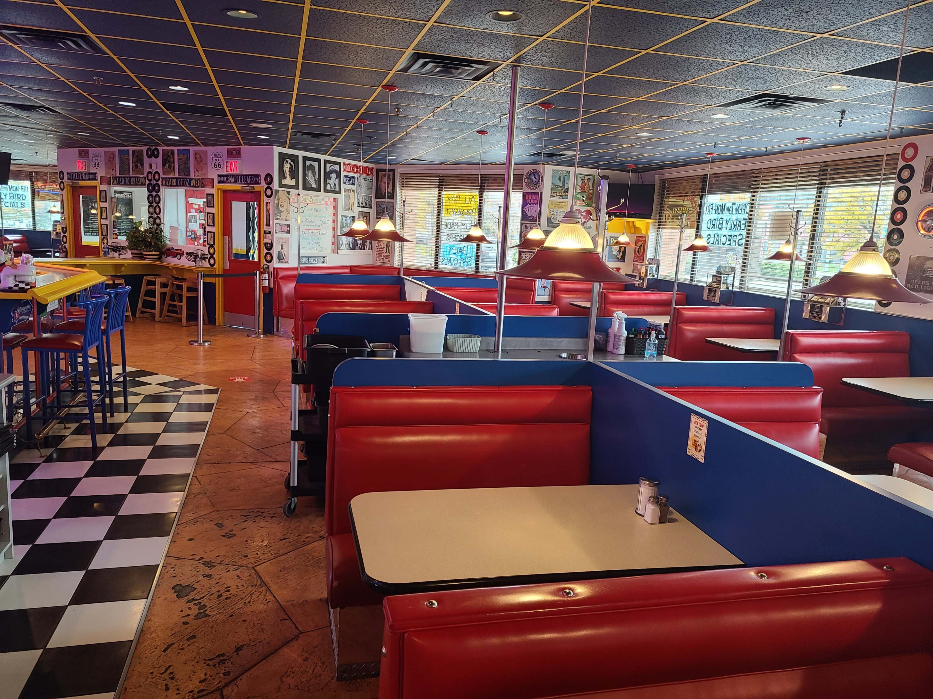 The image shows an empty diner with red vinyl booths and a checkered floor.