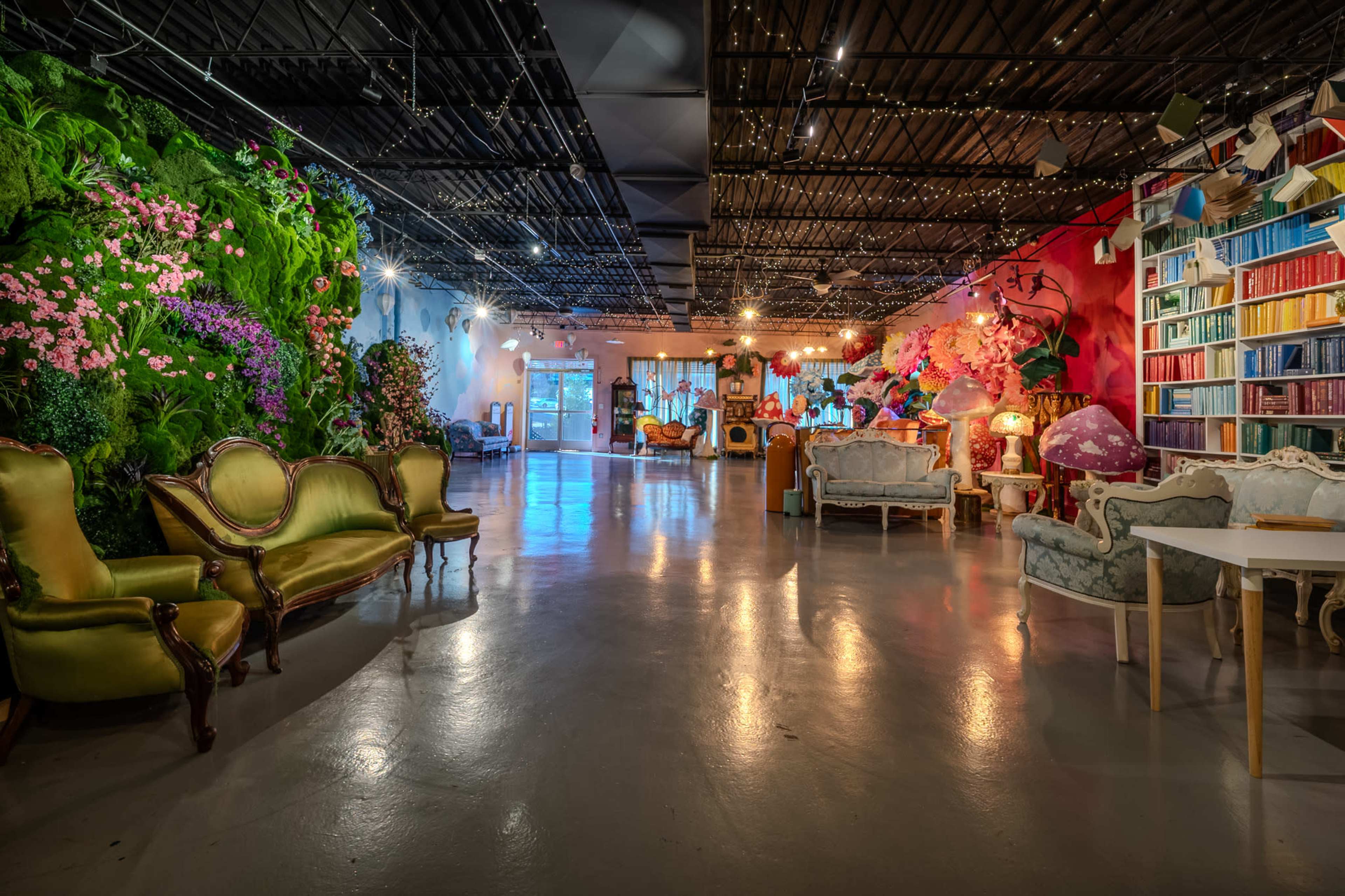 The image shows a spacious indoor area adorned with vibrant plants and flowers, featuring various stylish seating arrangements and decorative elements.
