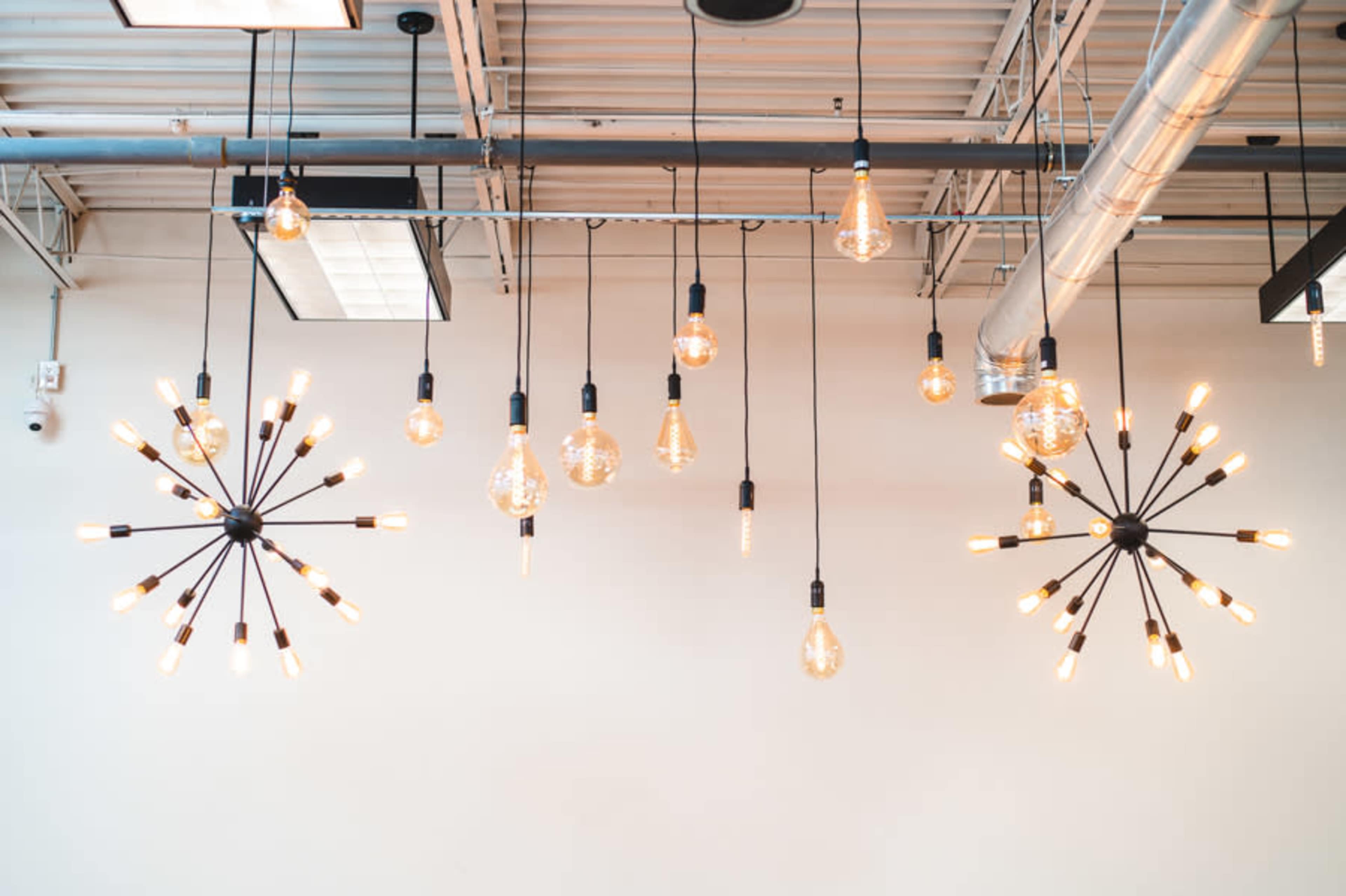 The image shows a variety of hanging light fixtures in different designs, illuminating a ceiling space.