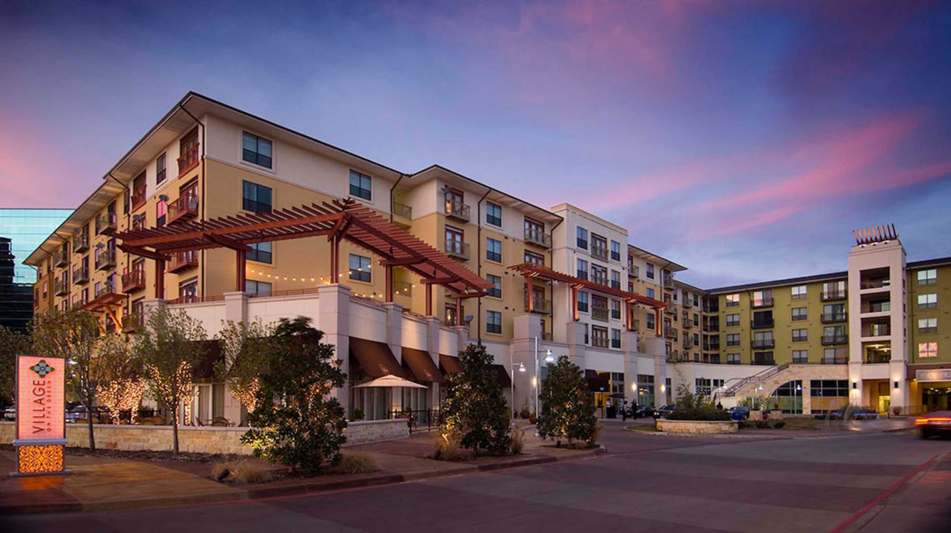 A modern multistory hotel building against a colorful sky during twilight.
