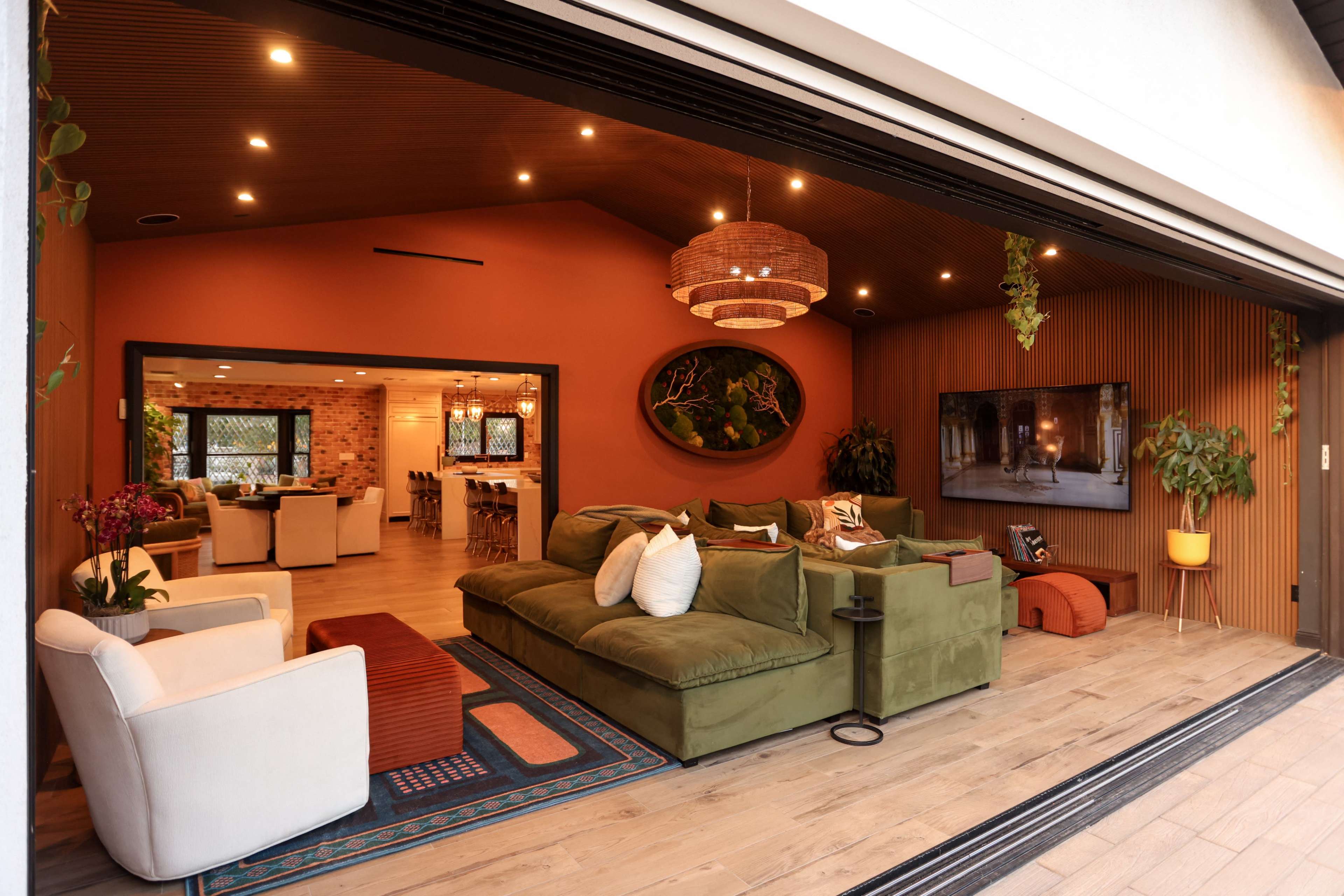 A spacious living area features a green sectional sofa and an open concept design that connects to the kitchen and dining area.