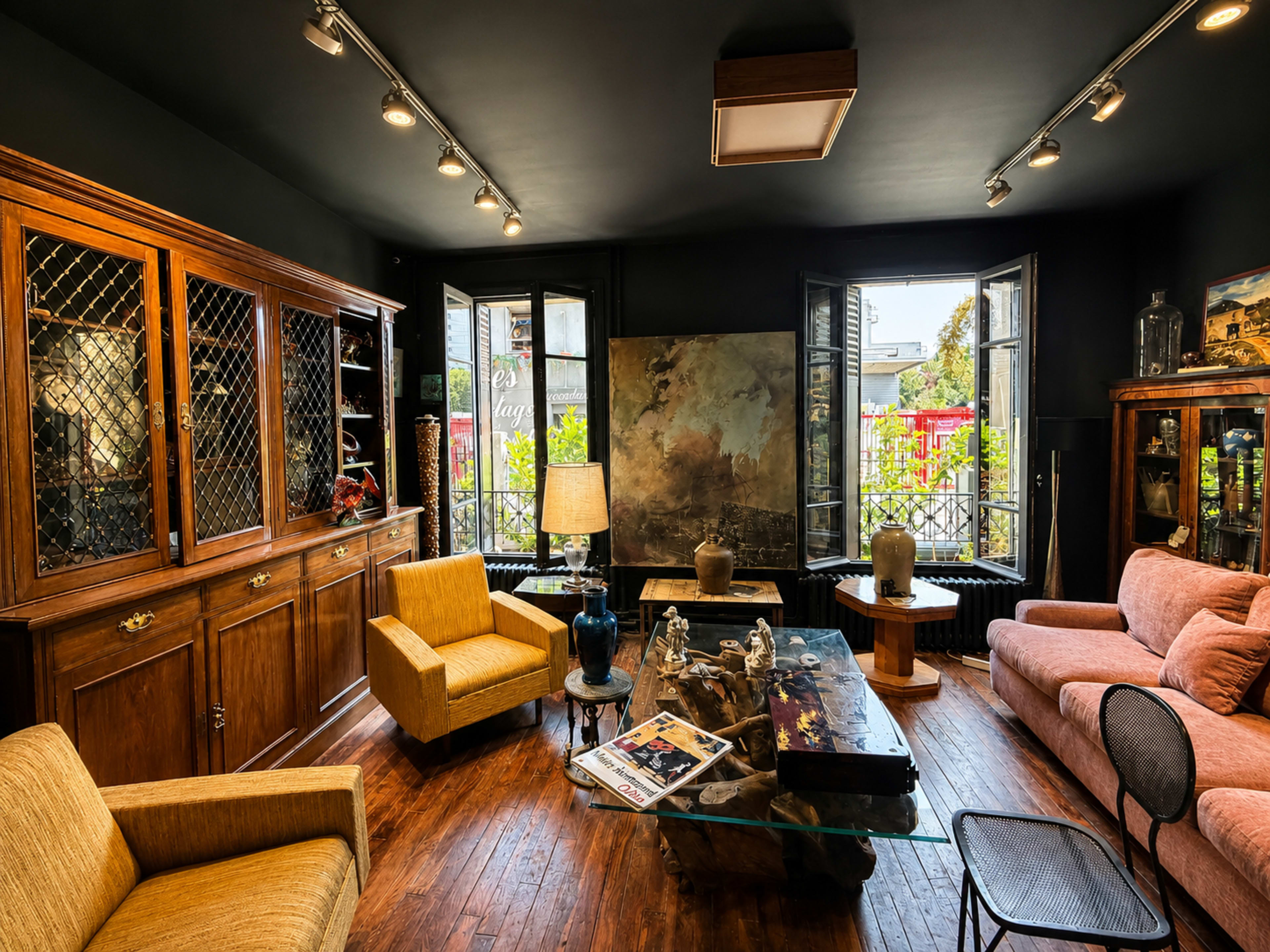 The image shows a cozy living room with dark walls, wooden furniture, large windows, and a mix of vintage and modern decor.