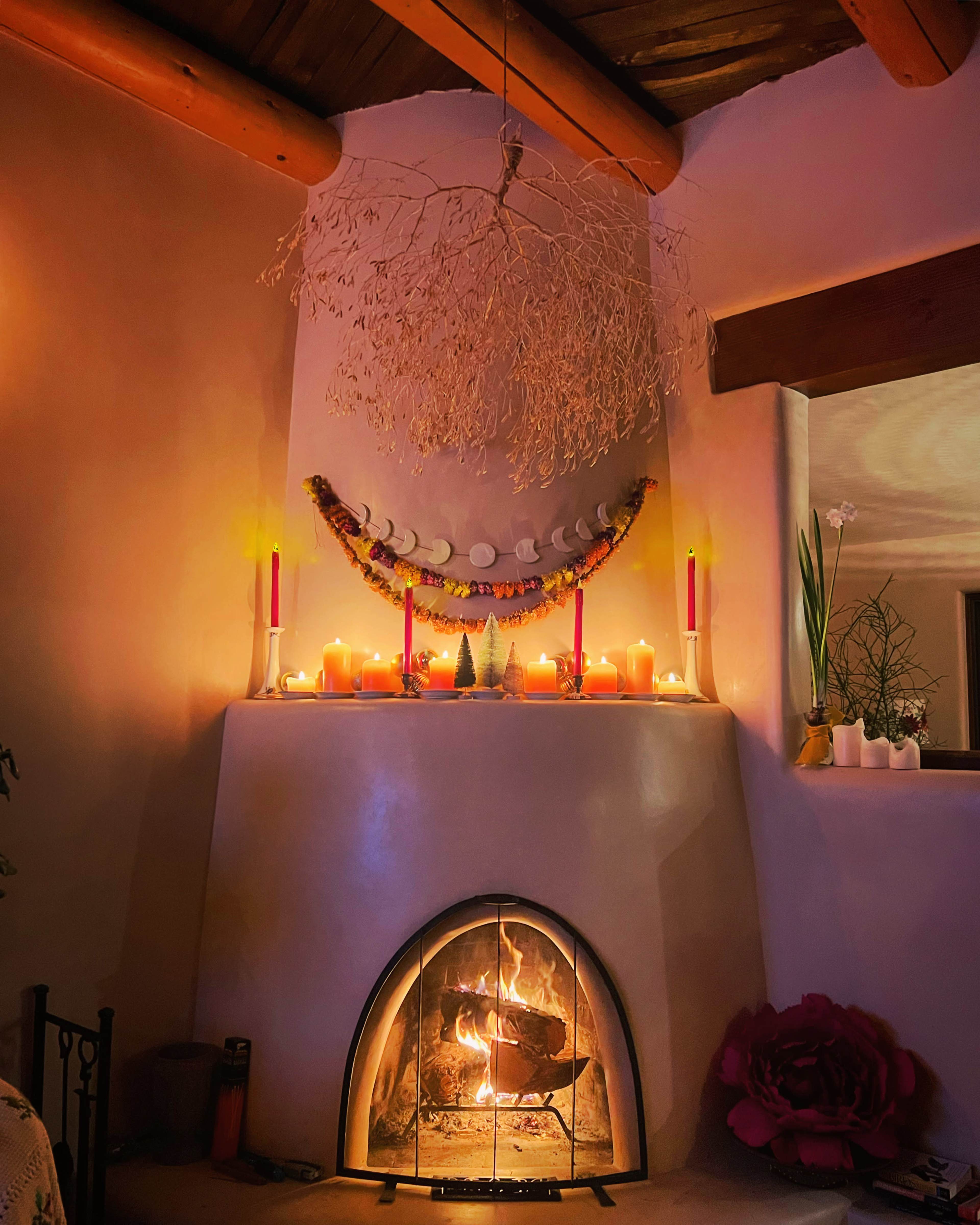 A cozy fireplace is adorned with candles and decorative items, creating a warm atmosphere in the room.