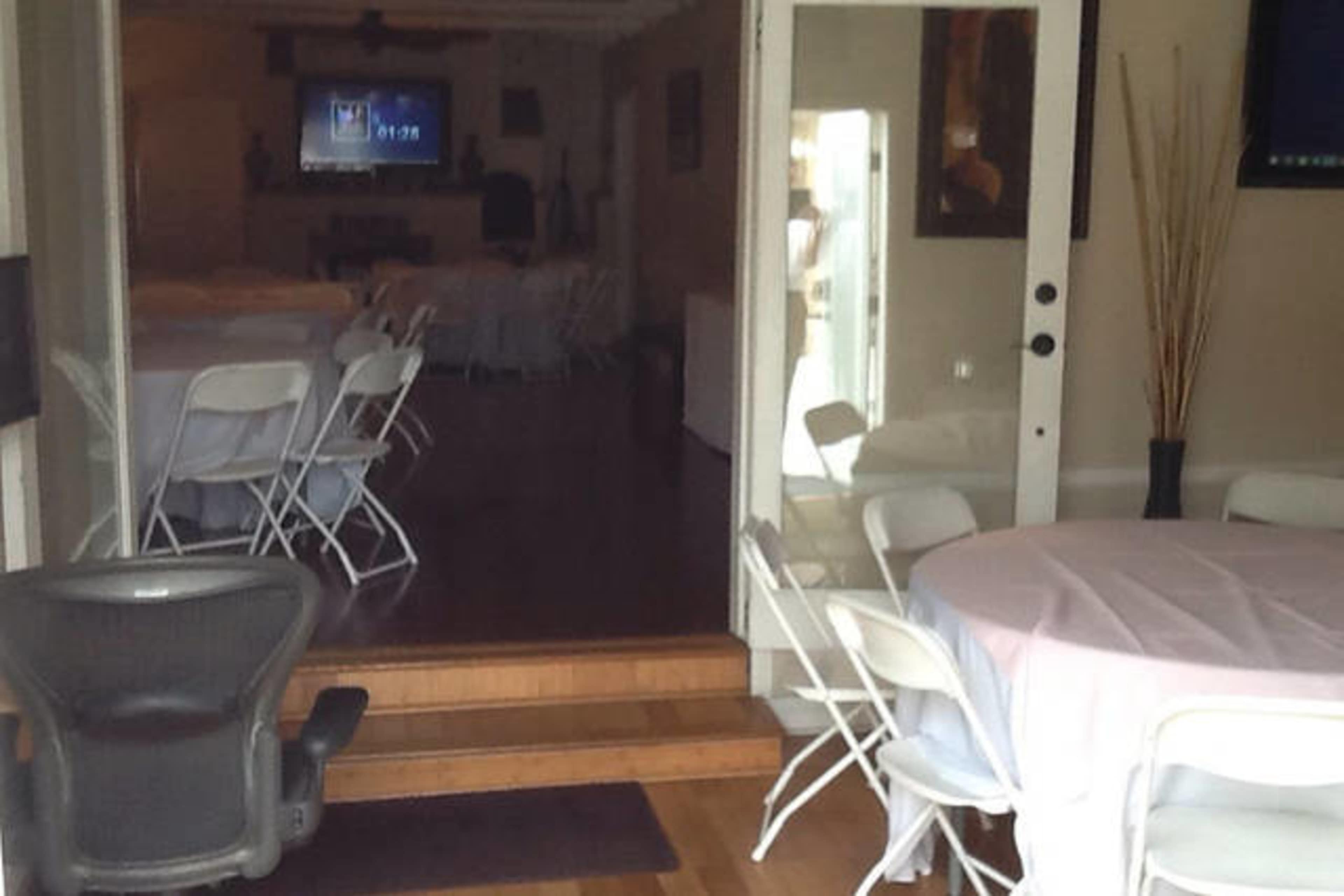 A doorway leads into a room set up with tables and chairs, visible in the background.