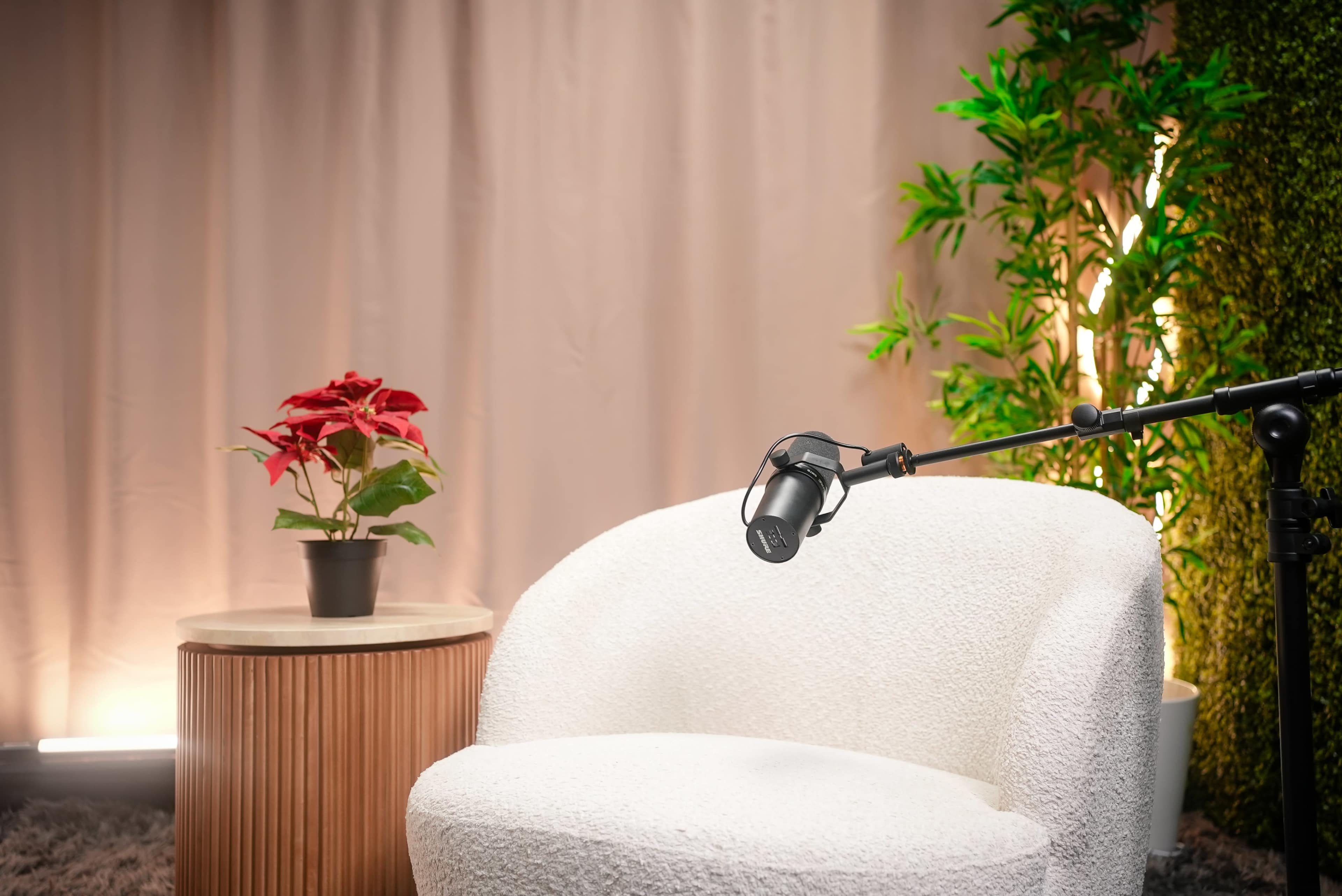 A cozy seating area features a white chair and a round side table with a potted plant, illuminated by soft lighting.