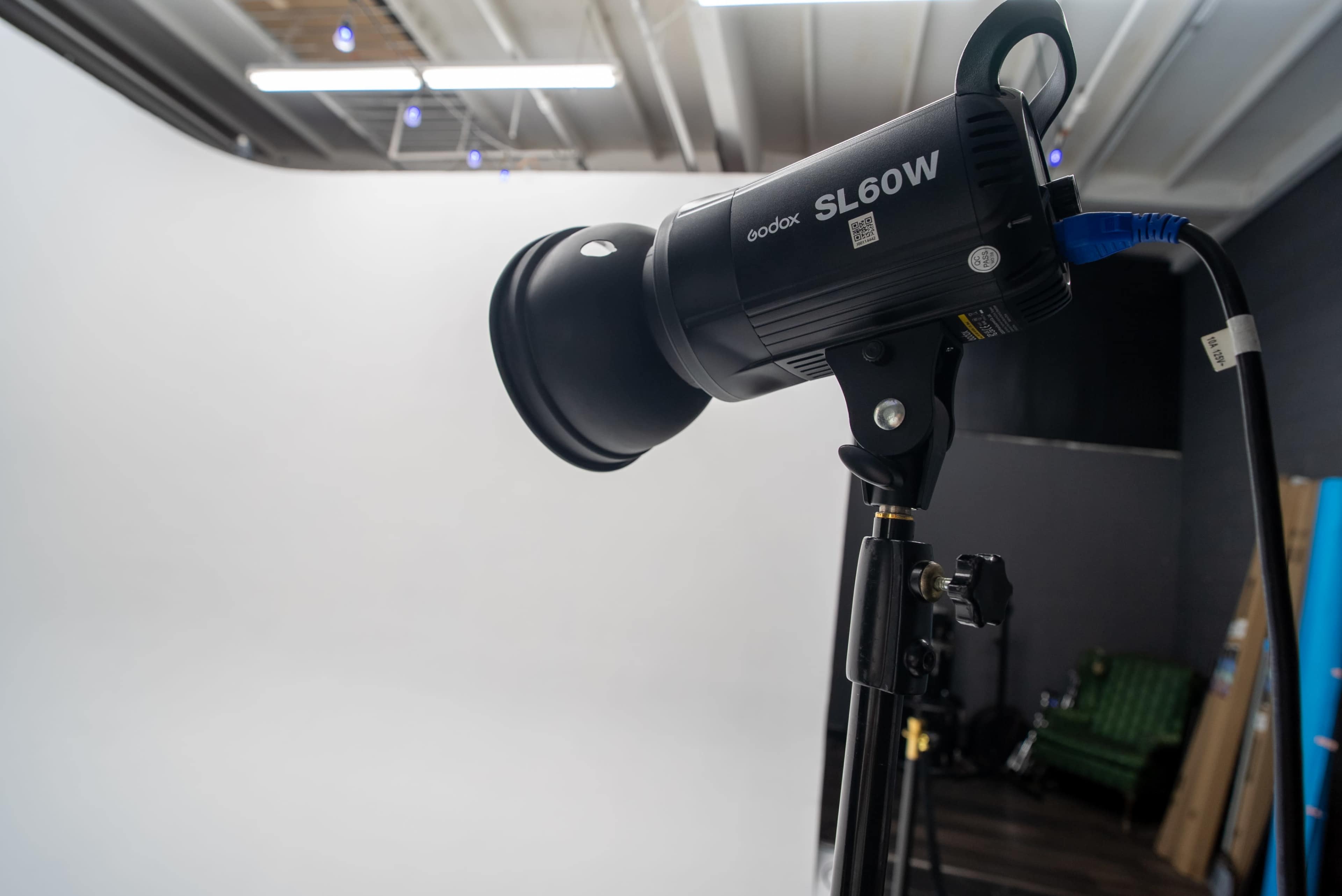 The image shows a Godox SL60W studio light mounted on a stand, positioned in front of a plain white backdrop.