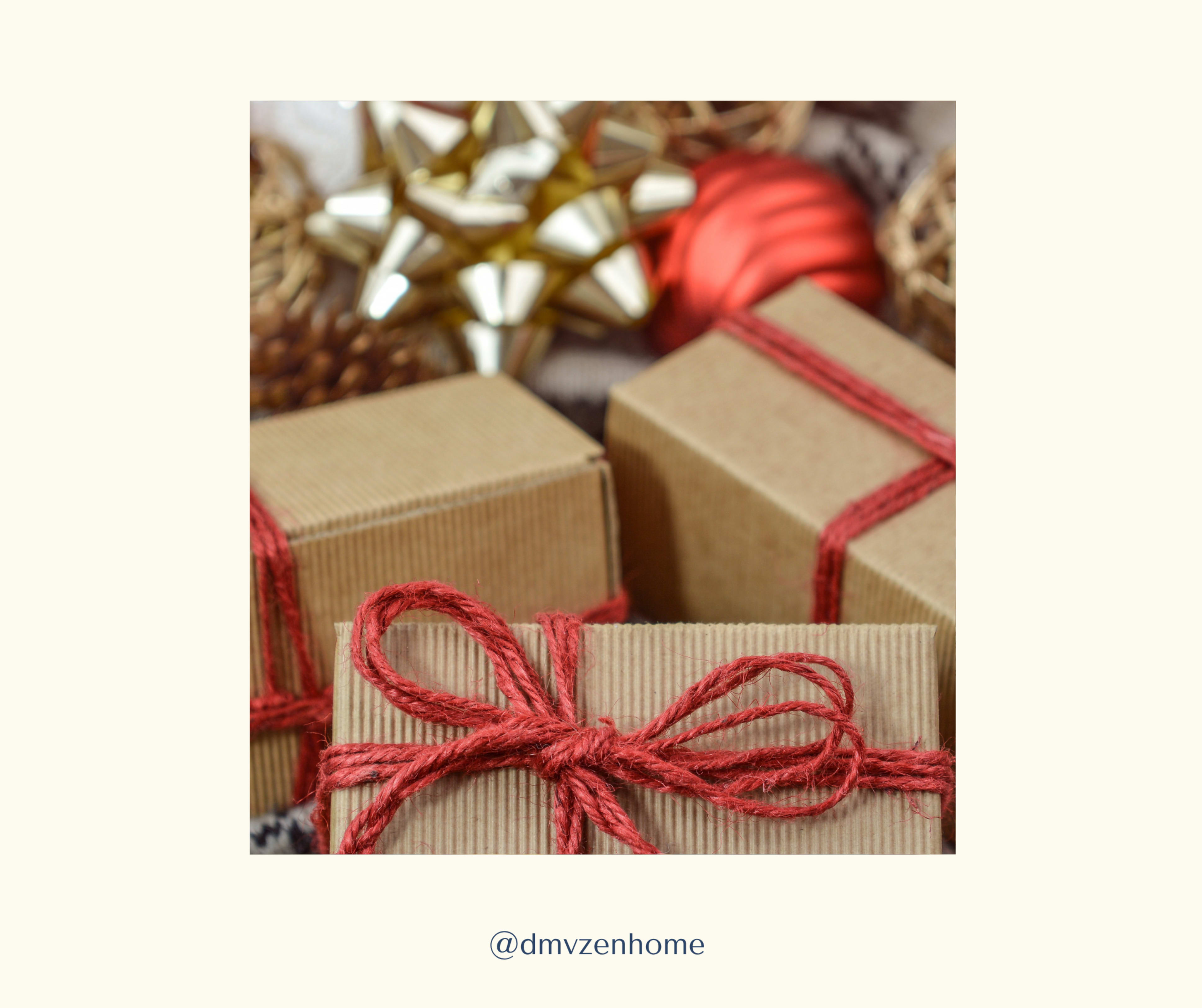 The image features several gift boxes wrapped in brown paper and tied with red string, alongside decorative holiday items such as a golden bow and Christmas ornaments.