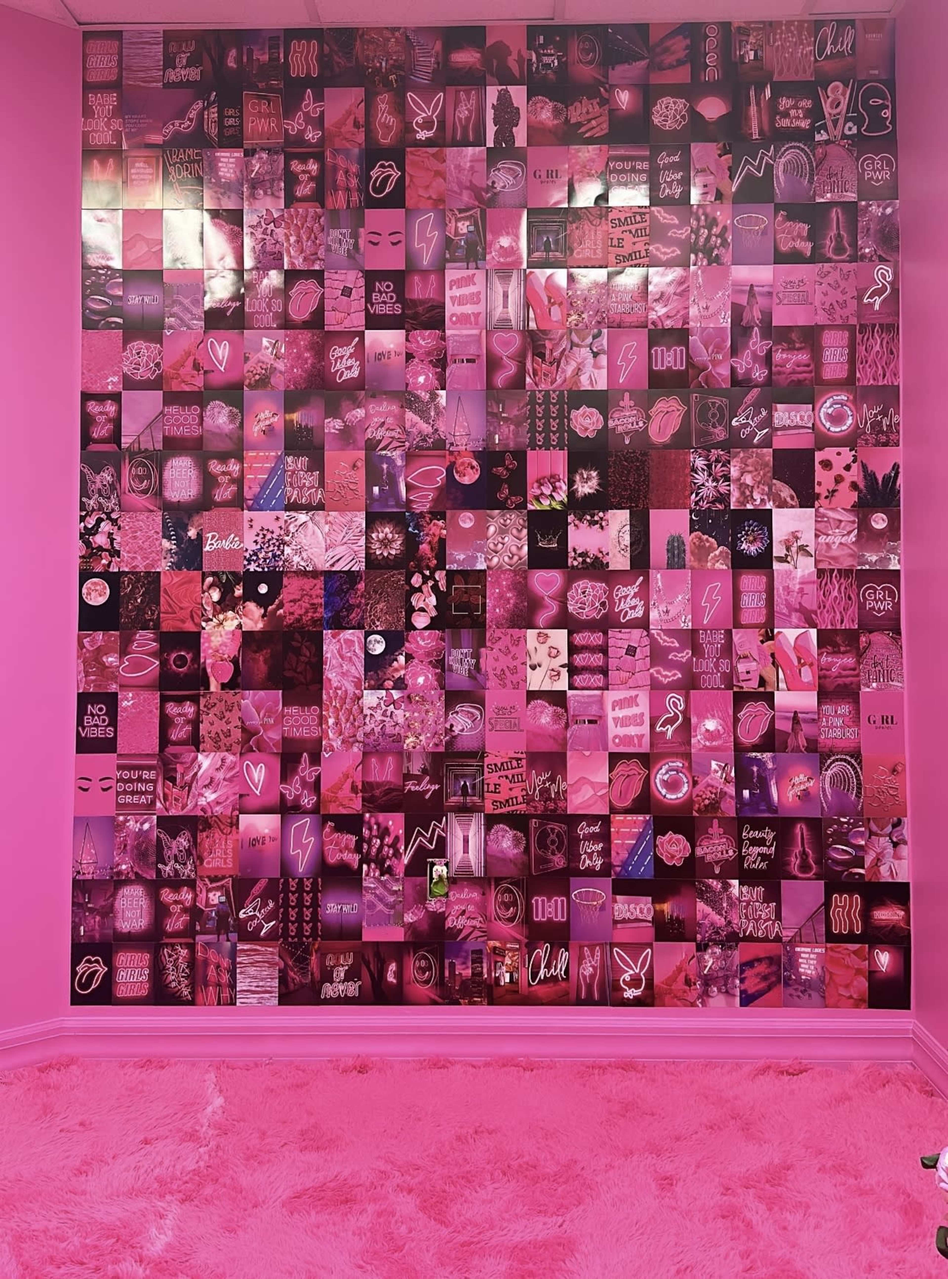 A pink wall covered with a collage of various patterned and graphic prints in shades of pink.