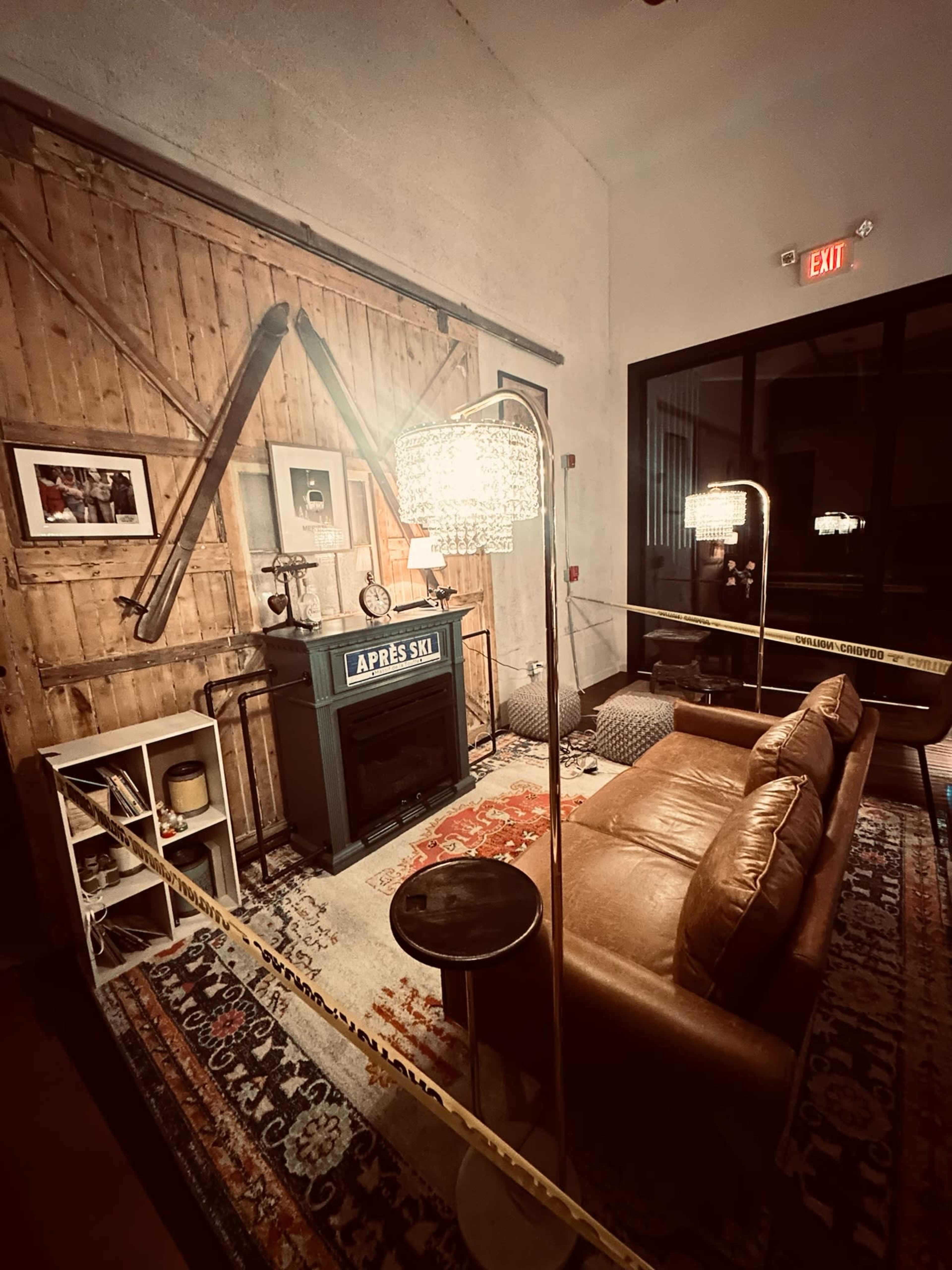 The image shows a cozy lounge area with a brown leather sofa, a table, and a vintage fireplace, surrounded by decorative items and marked off with caution tape.