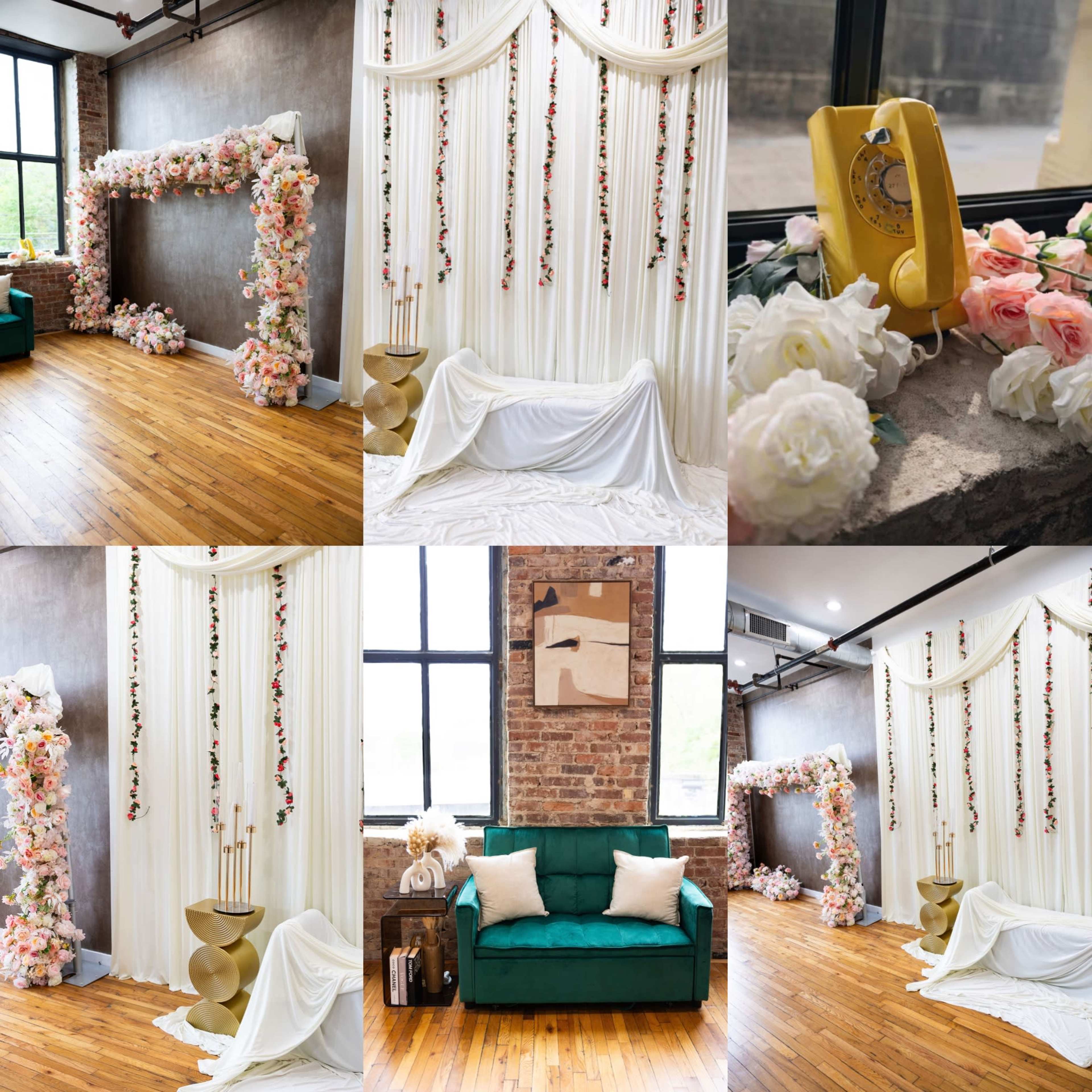 The image displays a stylish indoor event space featuring a floral backdrop, draped fabric, a vintage telephone, and various decorative elements, all complemented by wooden flooring and large windows.