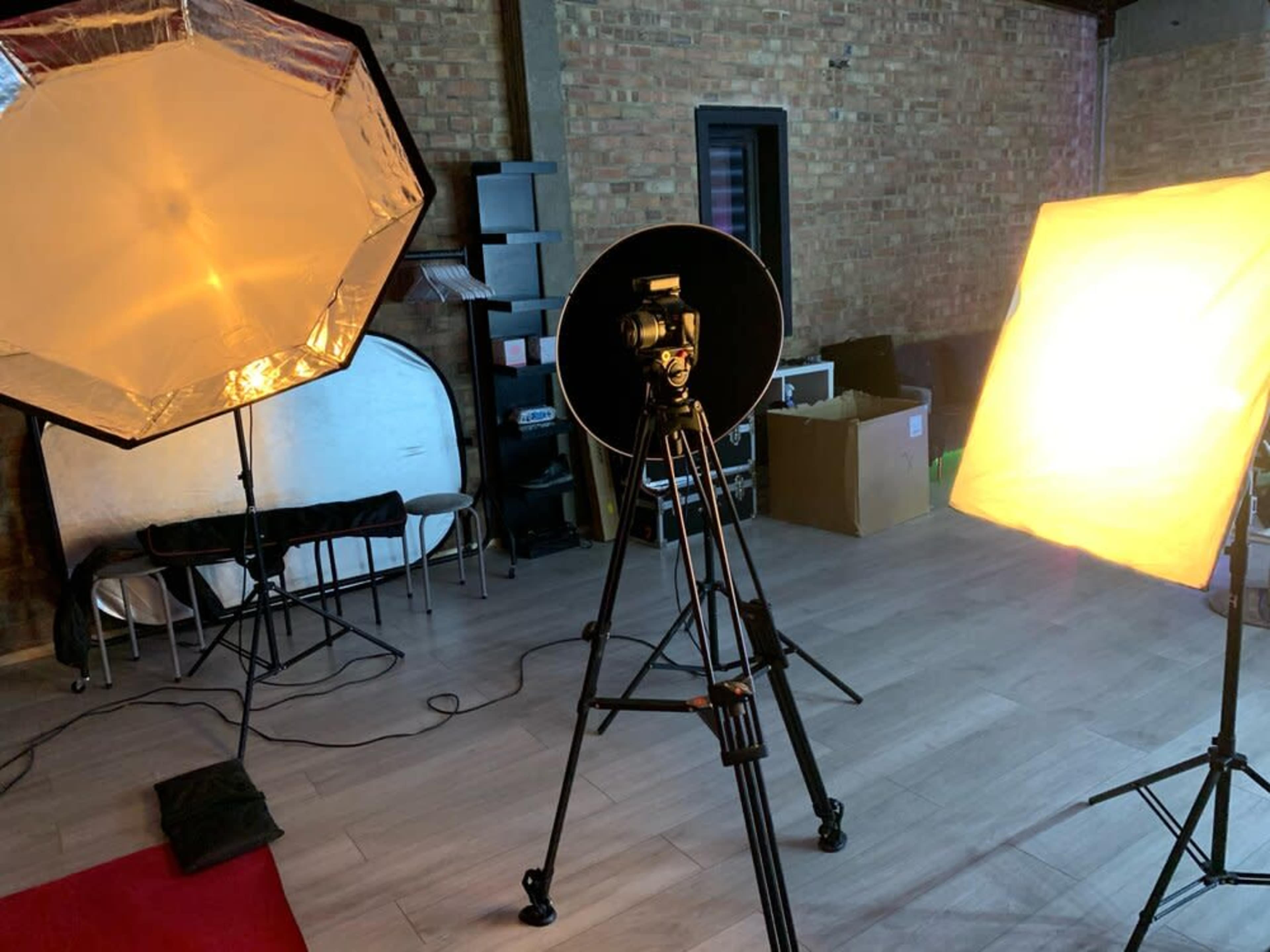 A photography setup featuring a camera on a tripod, with two softbox lights positioned to illuminate the scene.