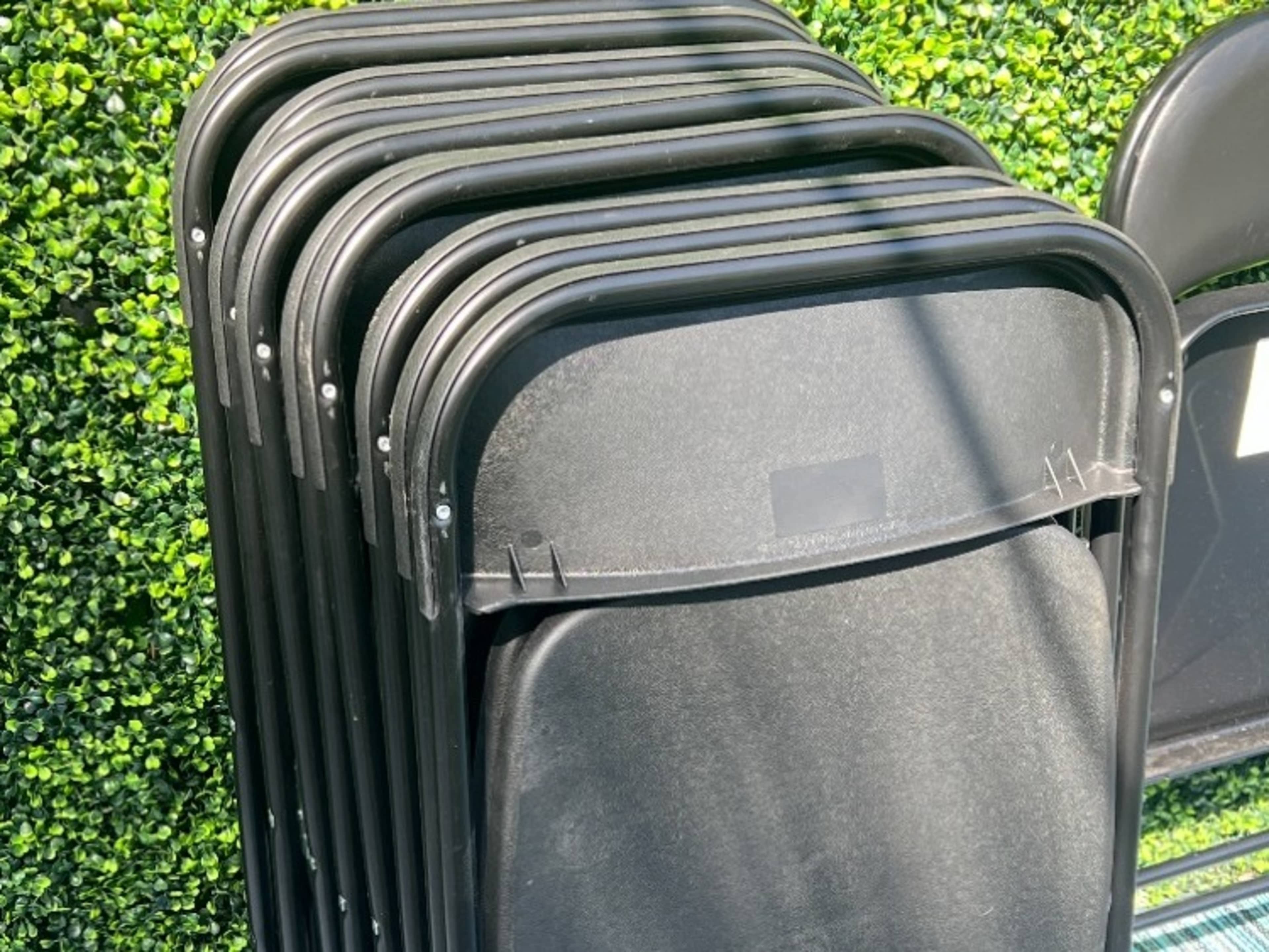 Ten black folding chairs