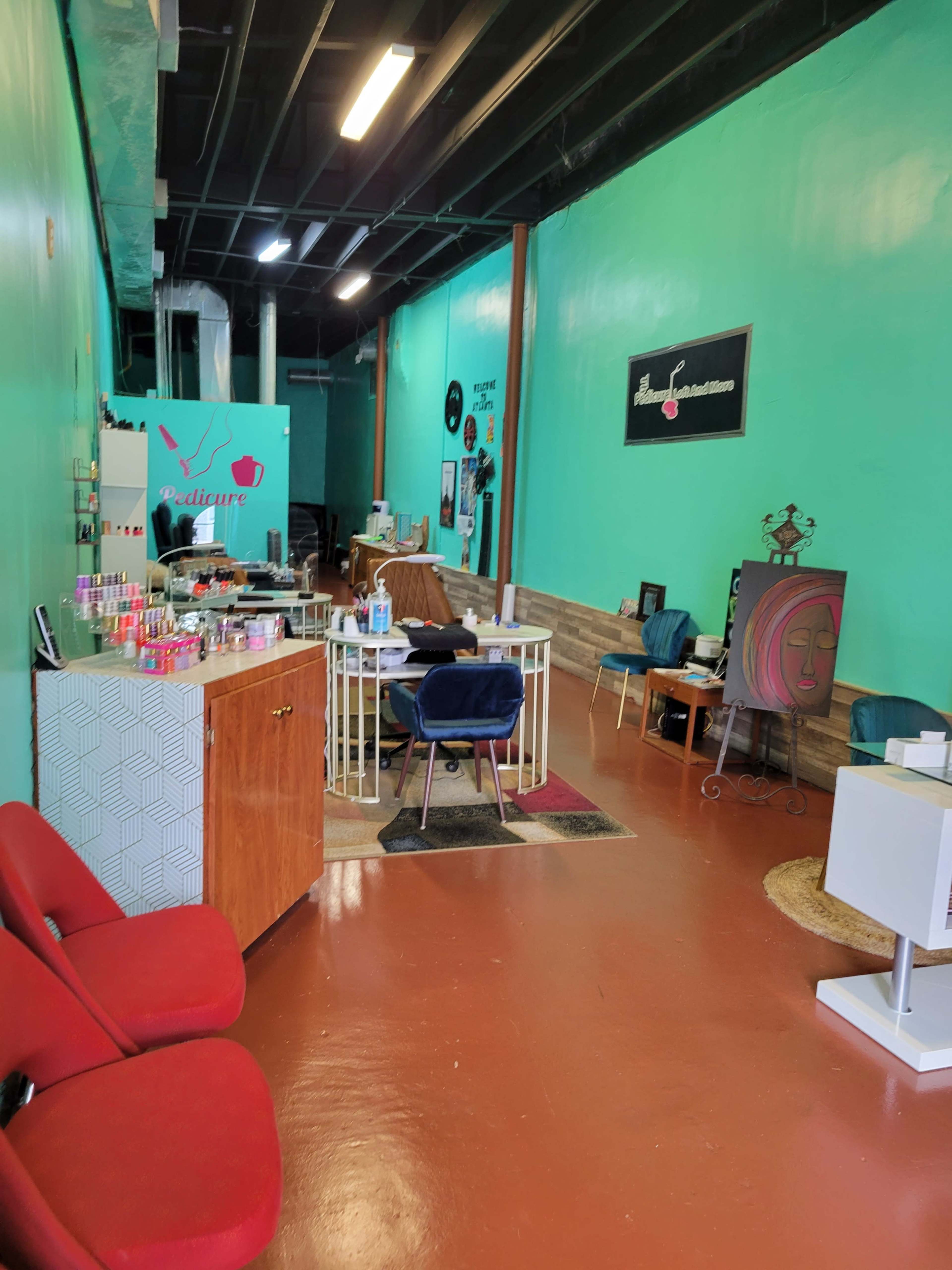 A brightly colored nail salon interior with teal walls, various furniture items, and a reception area featuring a display of nail products.