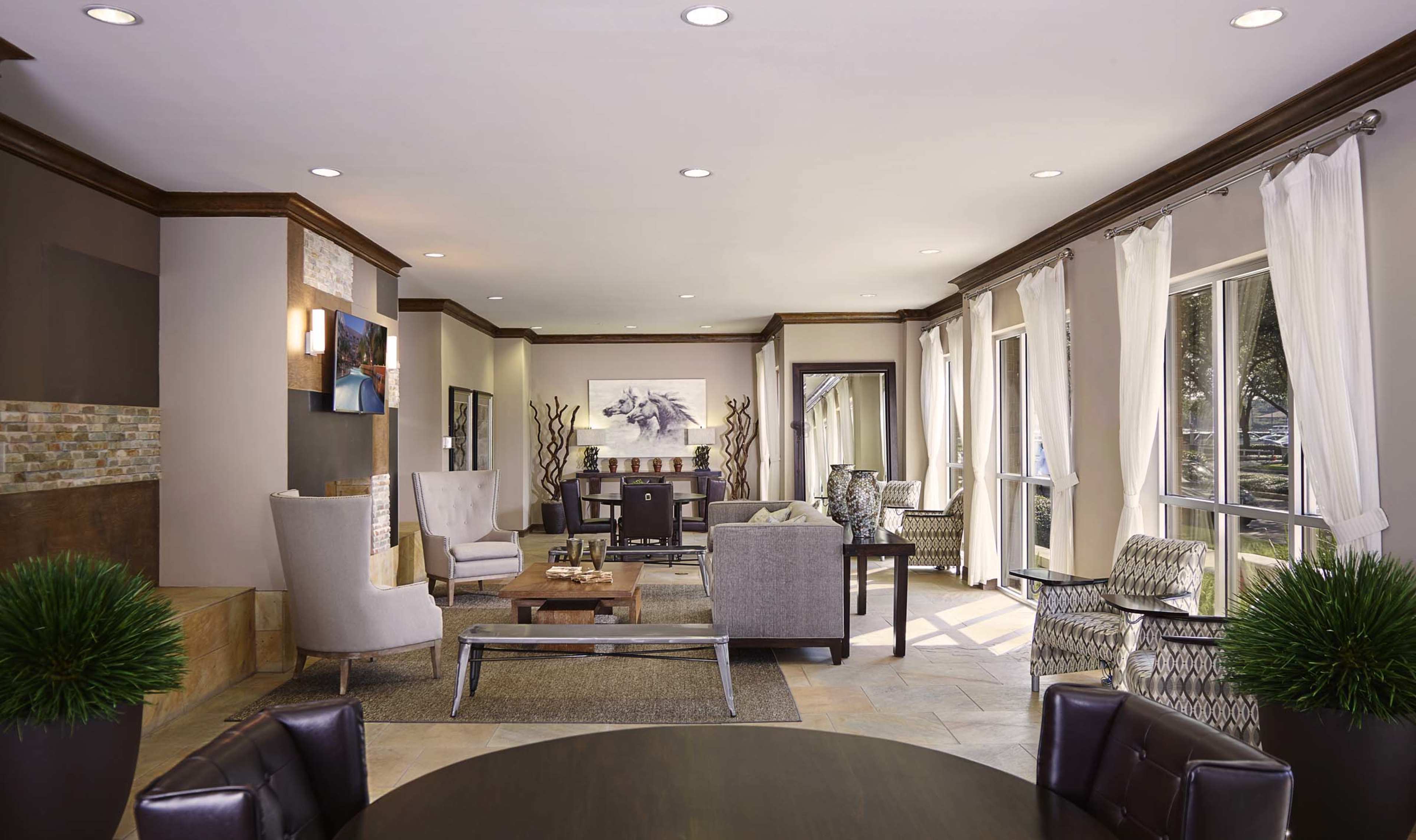A modern living area with comfortable seating, large windows, and a combination of wooden and stone accents.