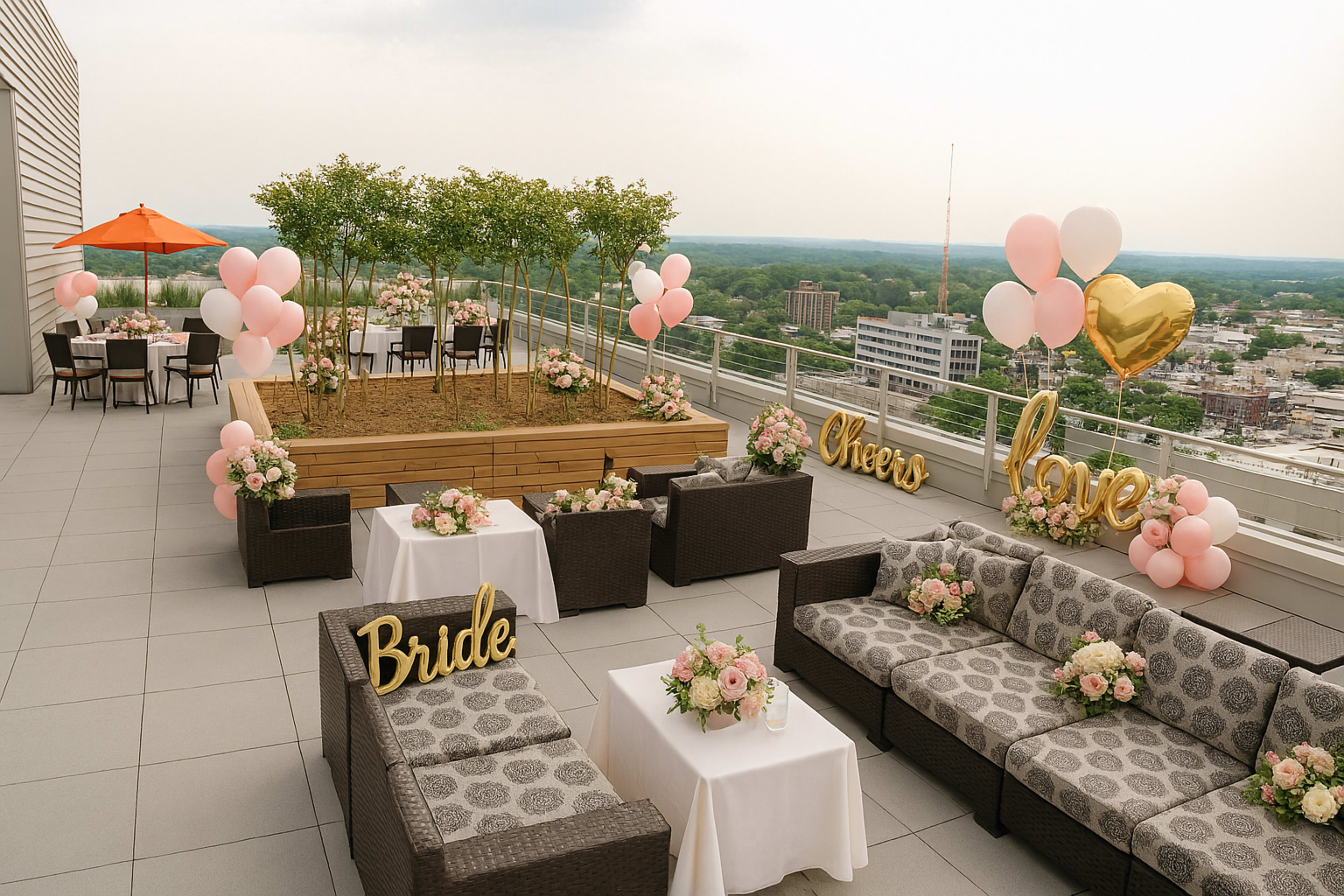 The image shows a rooftop event space decorated for a wedding celebration, featuring seating areas, floral arrangements, and balloon displays.