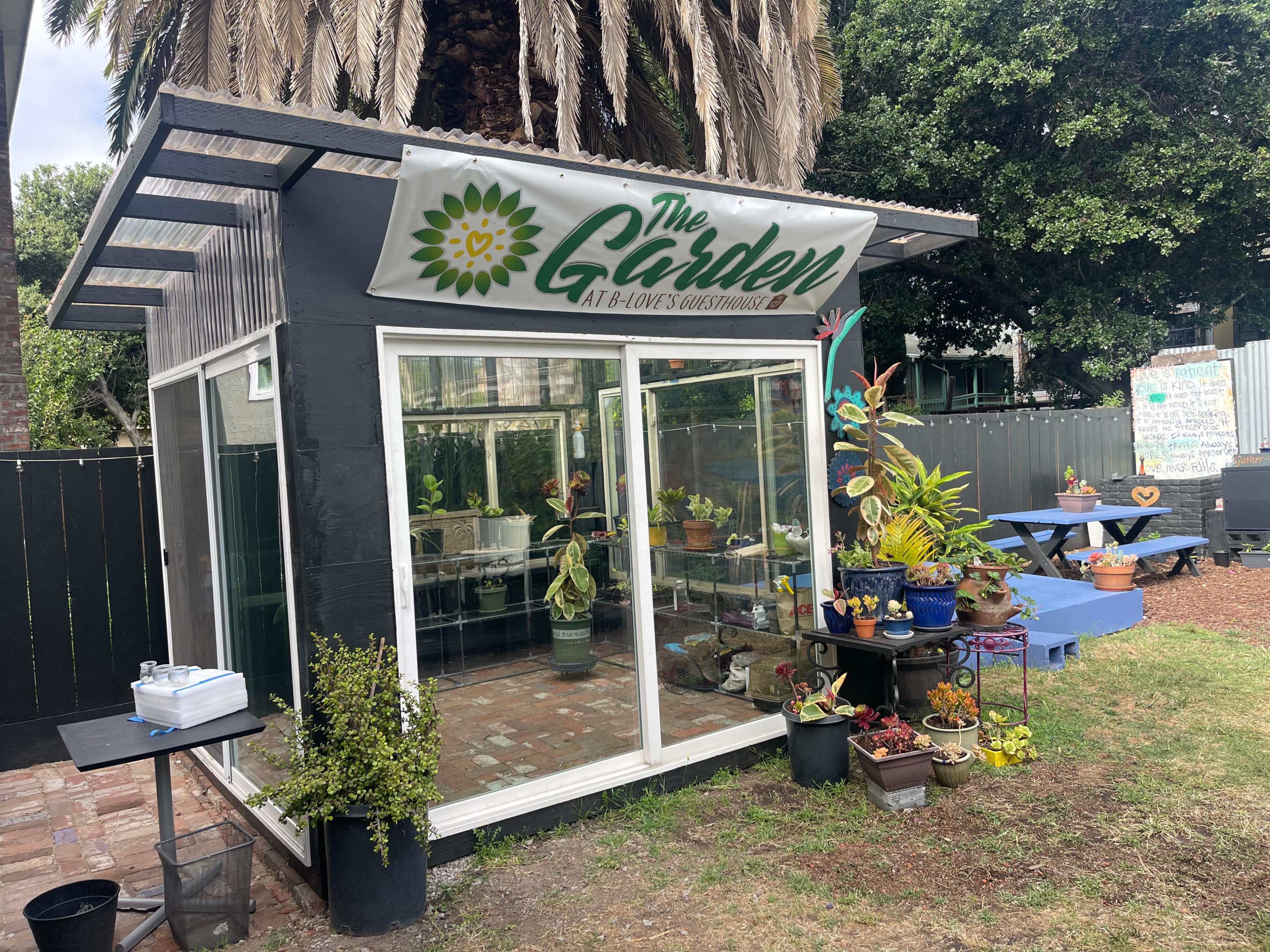 A greenhouse named "The Garden" features plants displayed inside and around it, with seating areas visible outside.