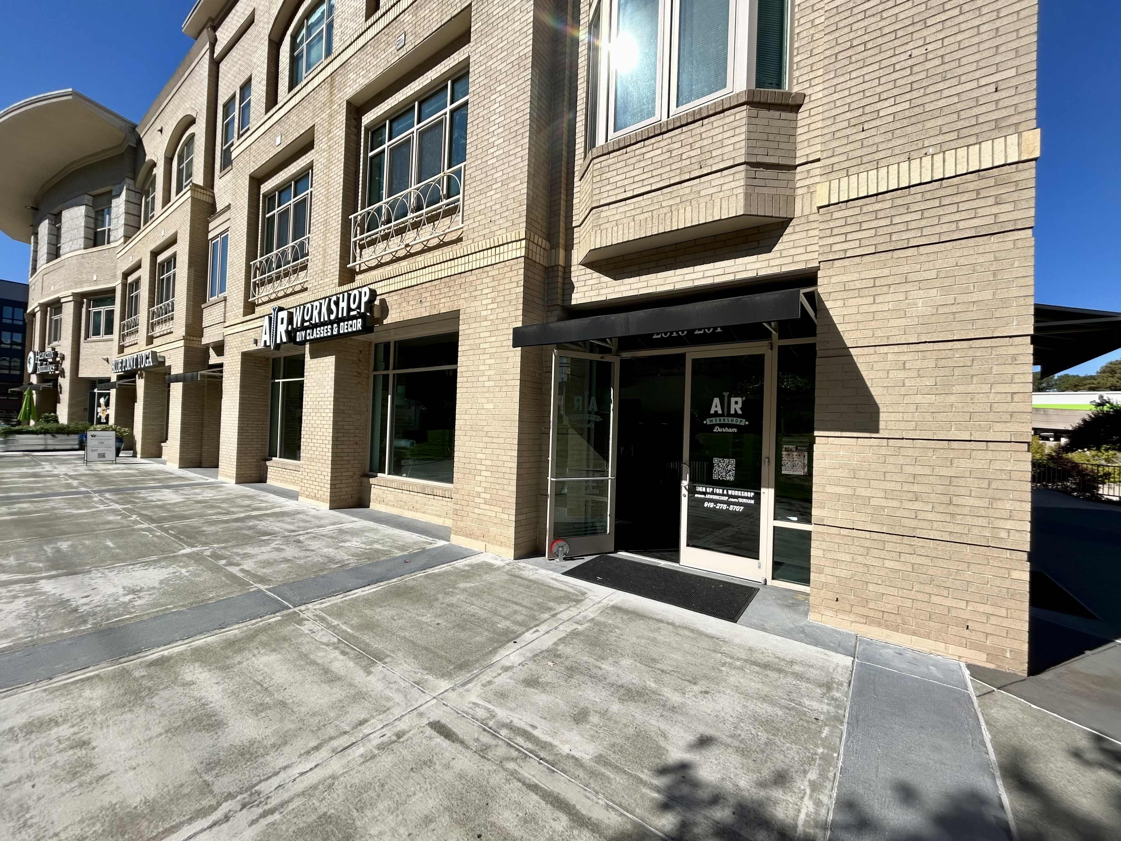 The exterior of a building with large windows and a storefront labeled "AIR" beside a shop called "Roxyshop."