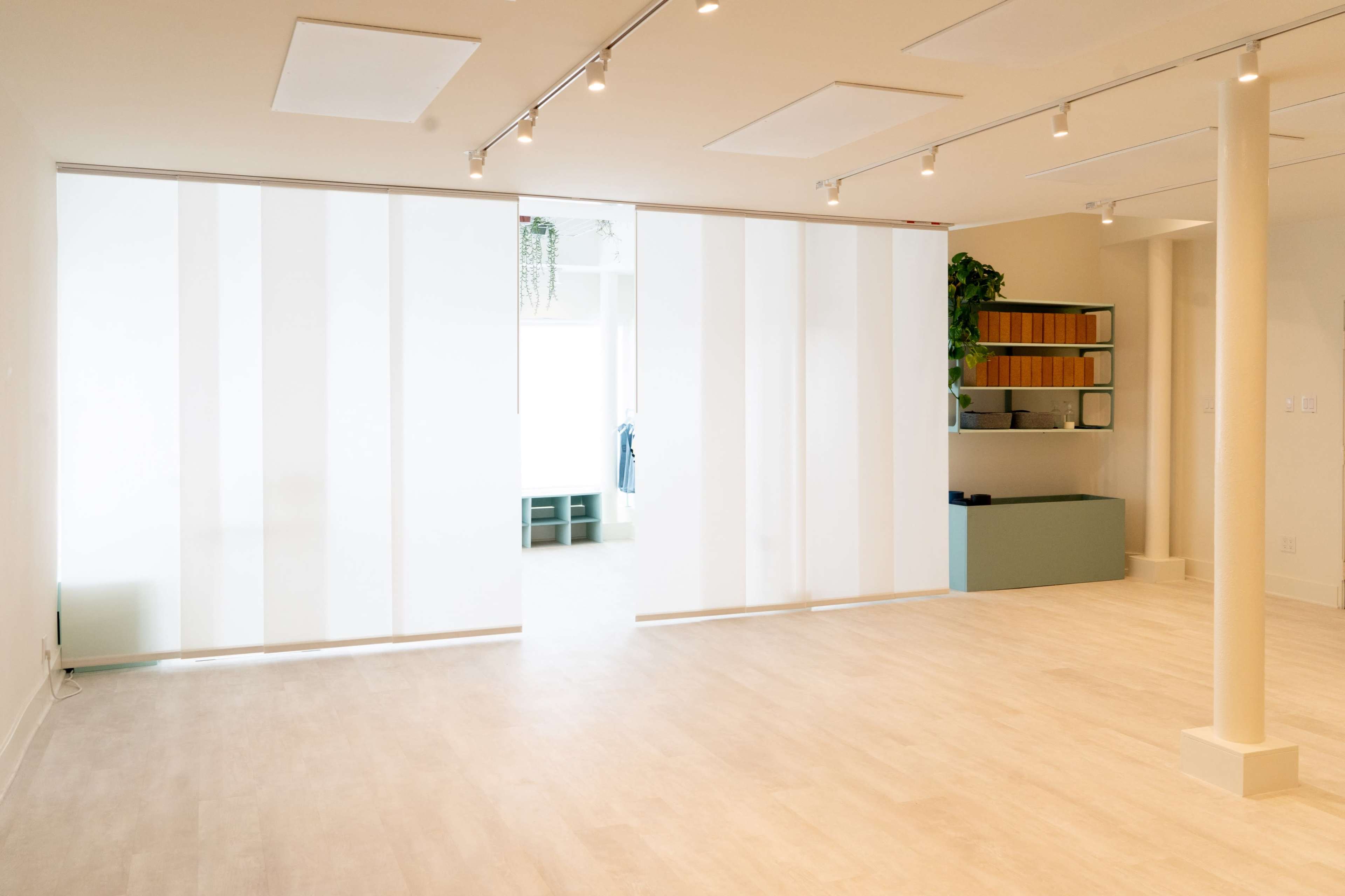 A spacious, well-lit interior with a large, frosted glass partition and minimalist furnishings.