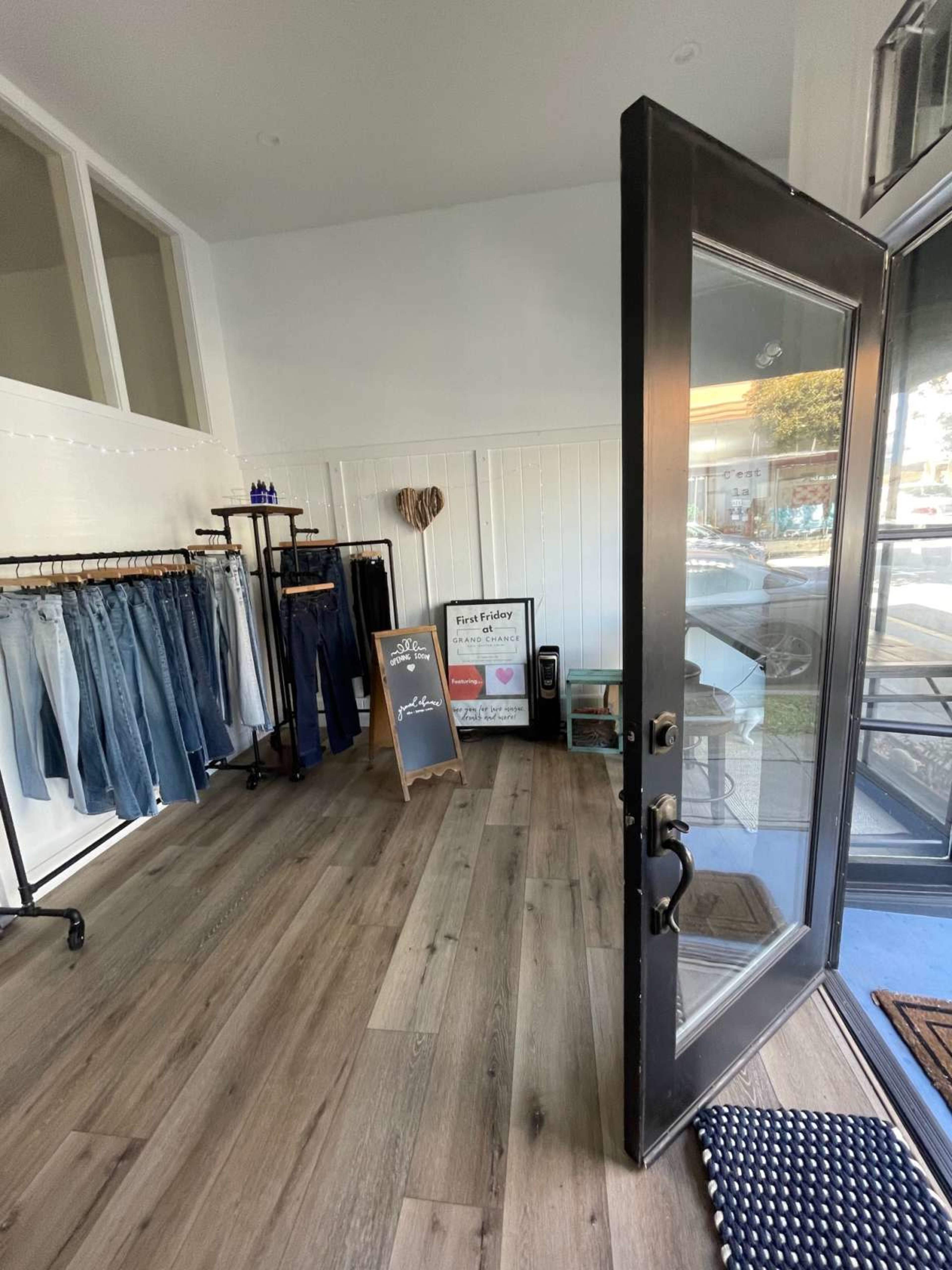The interior of a clothing store with racks of jeans and a signboard near the entrance.