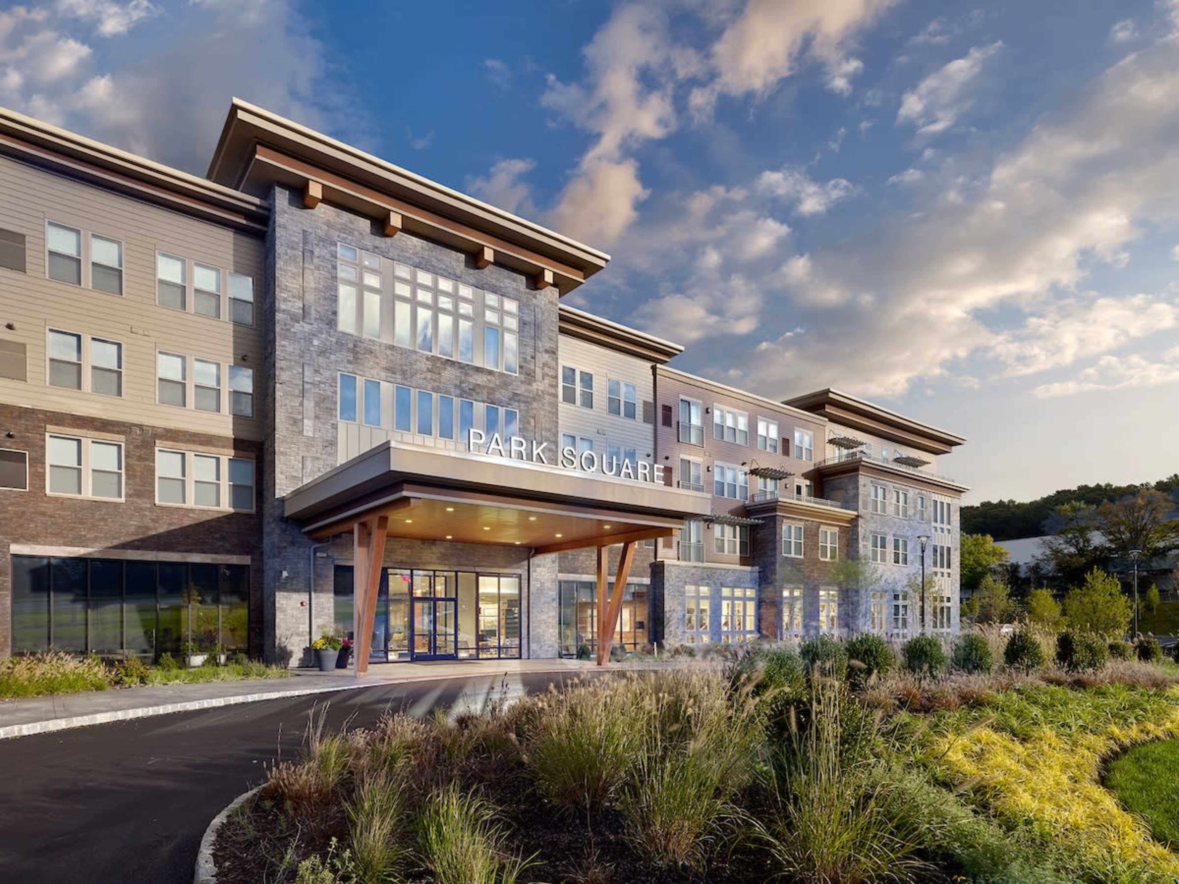 A modern multi-story building with a large entrance labeled "PARK SQUARE" and landscaped gardens in the foreground.