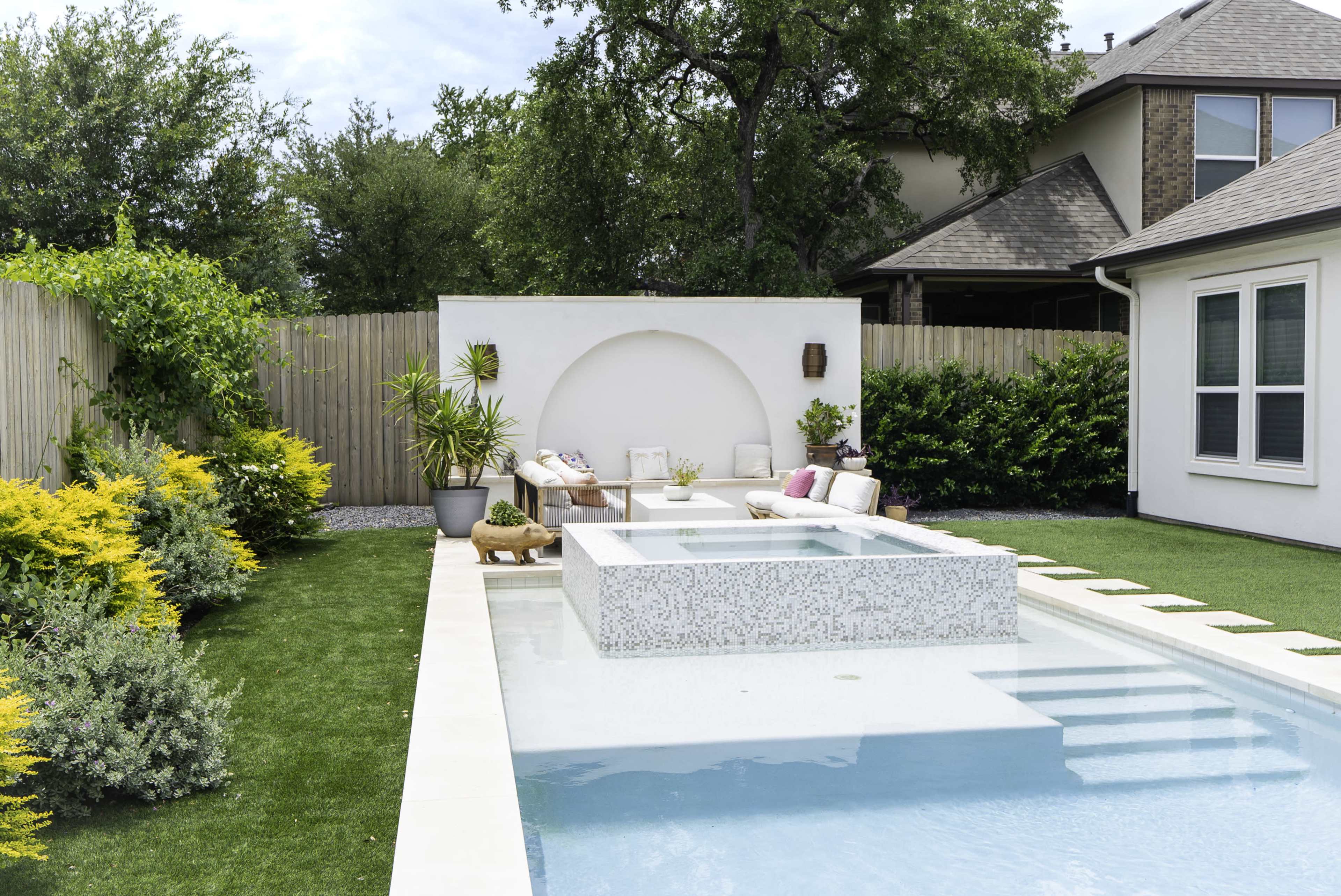 The image features a modern backyard with a rectangular swimming pool, surrounded by lush greenery and stylish outdoor furniture.