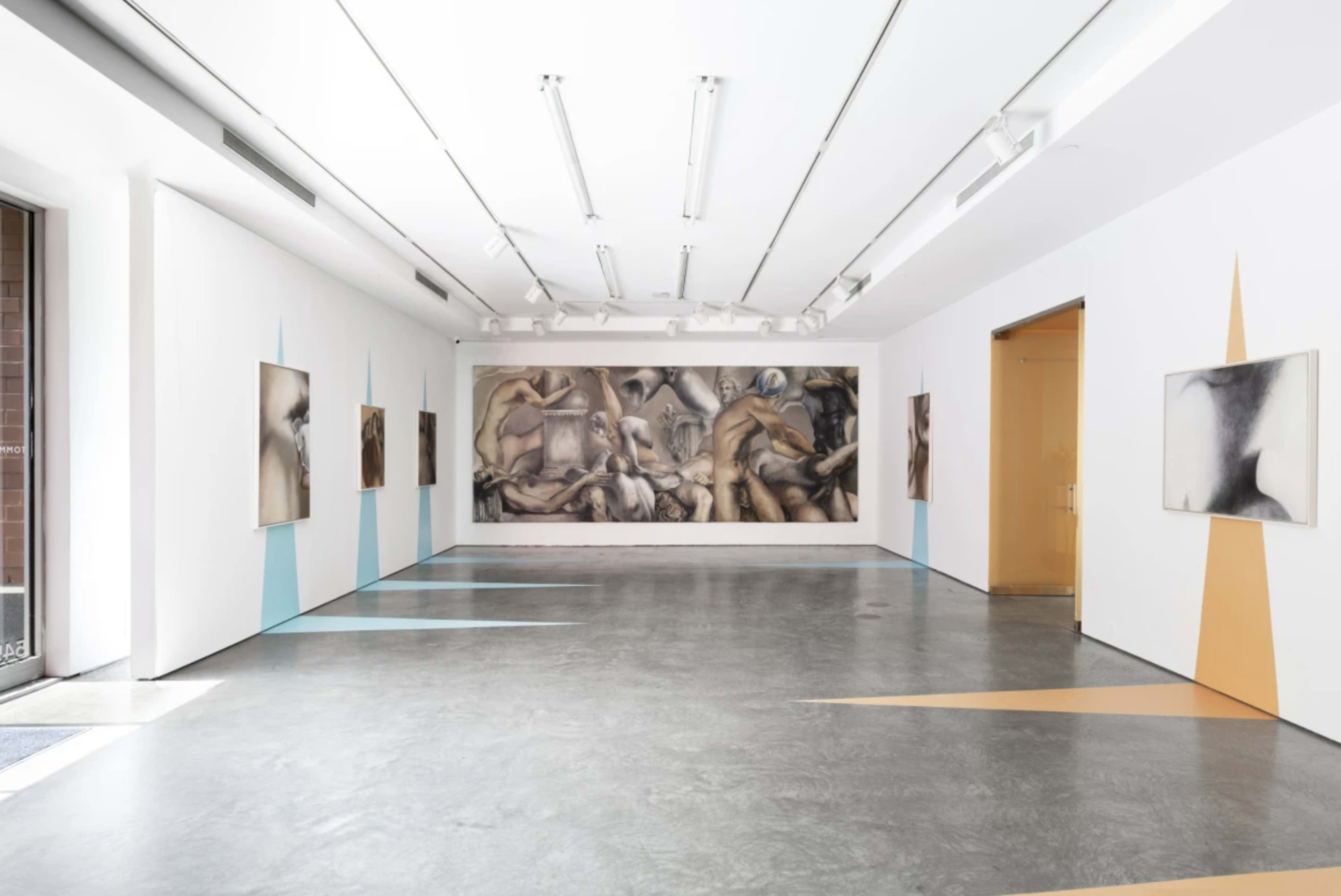 The image shows a modern art gallery with a large artwork on the back wall and smaller framed pieces on the side walls, featuring a minimalist design with geometric shapes on the floor.