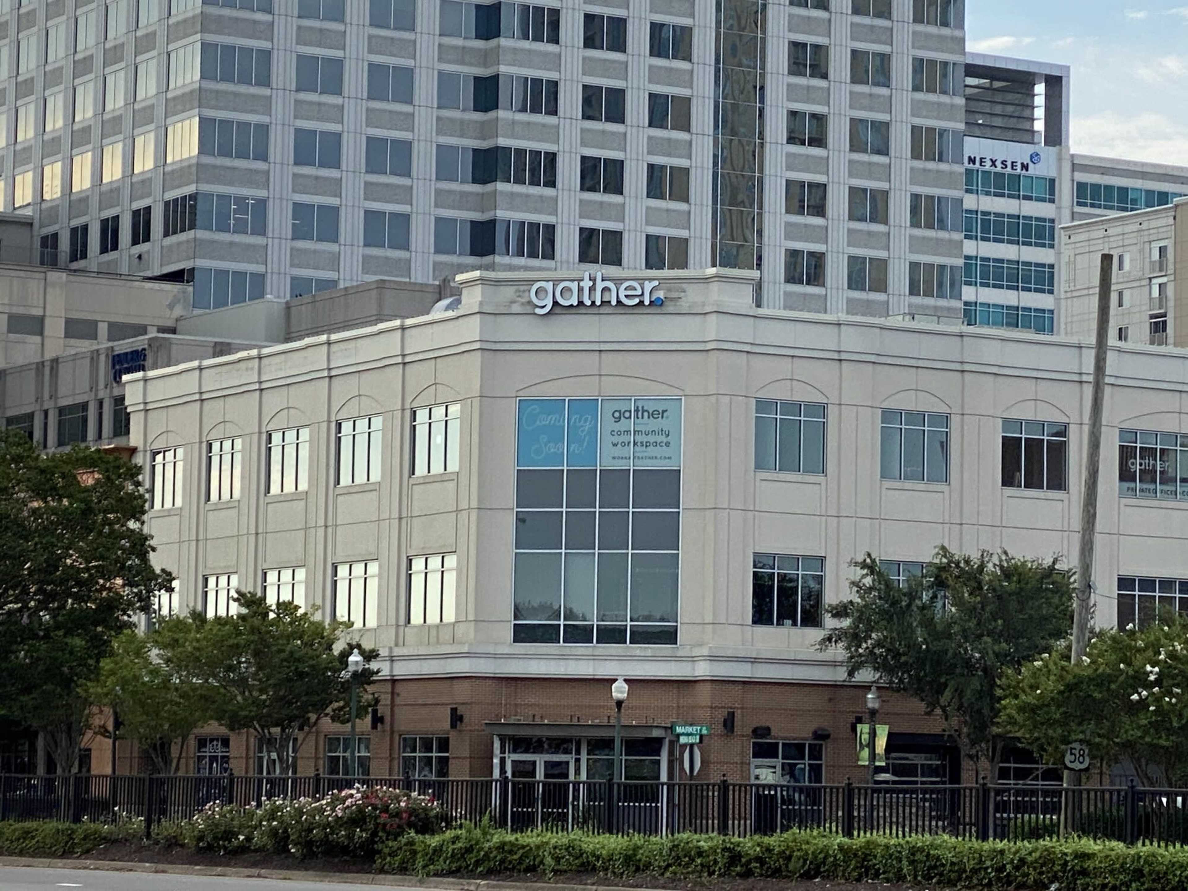 The image shows a multi-story building with the sign "gather" prominently displayed on the upper front, surrounded by modern high-rise structures.