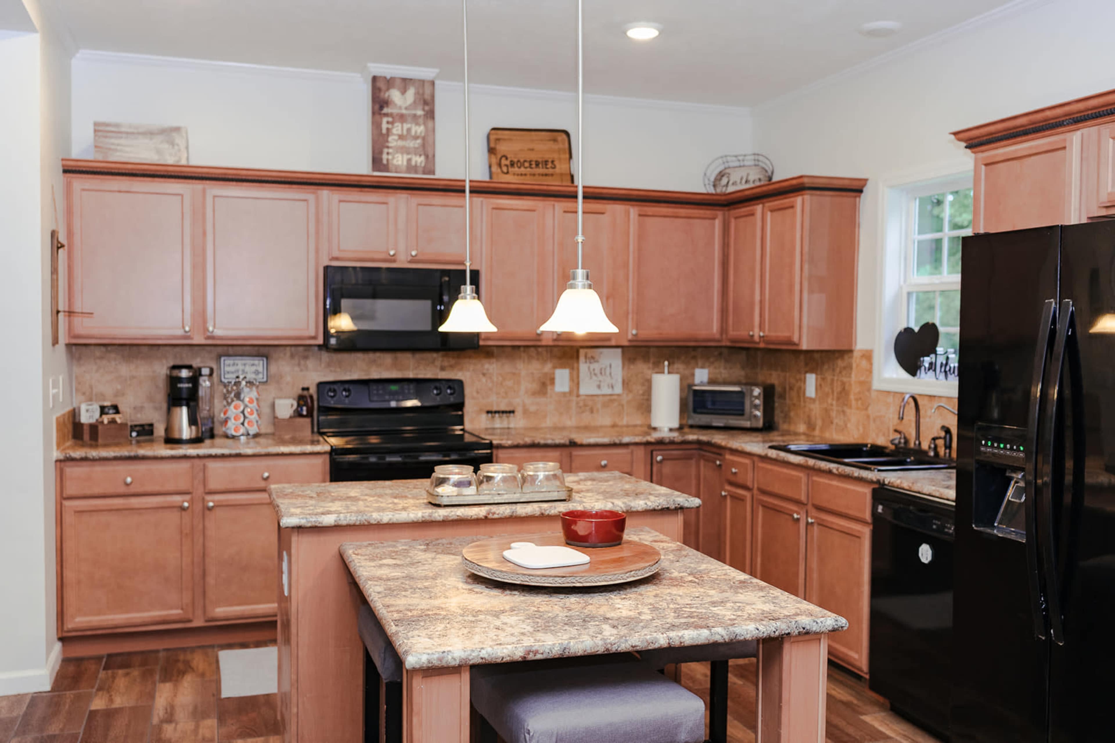 The kitchen features wooden cabinets with a central island, modern appliances, and pendant lighting.
