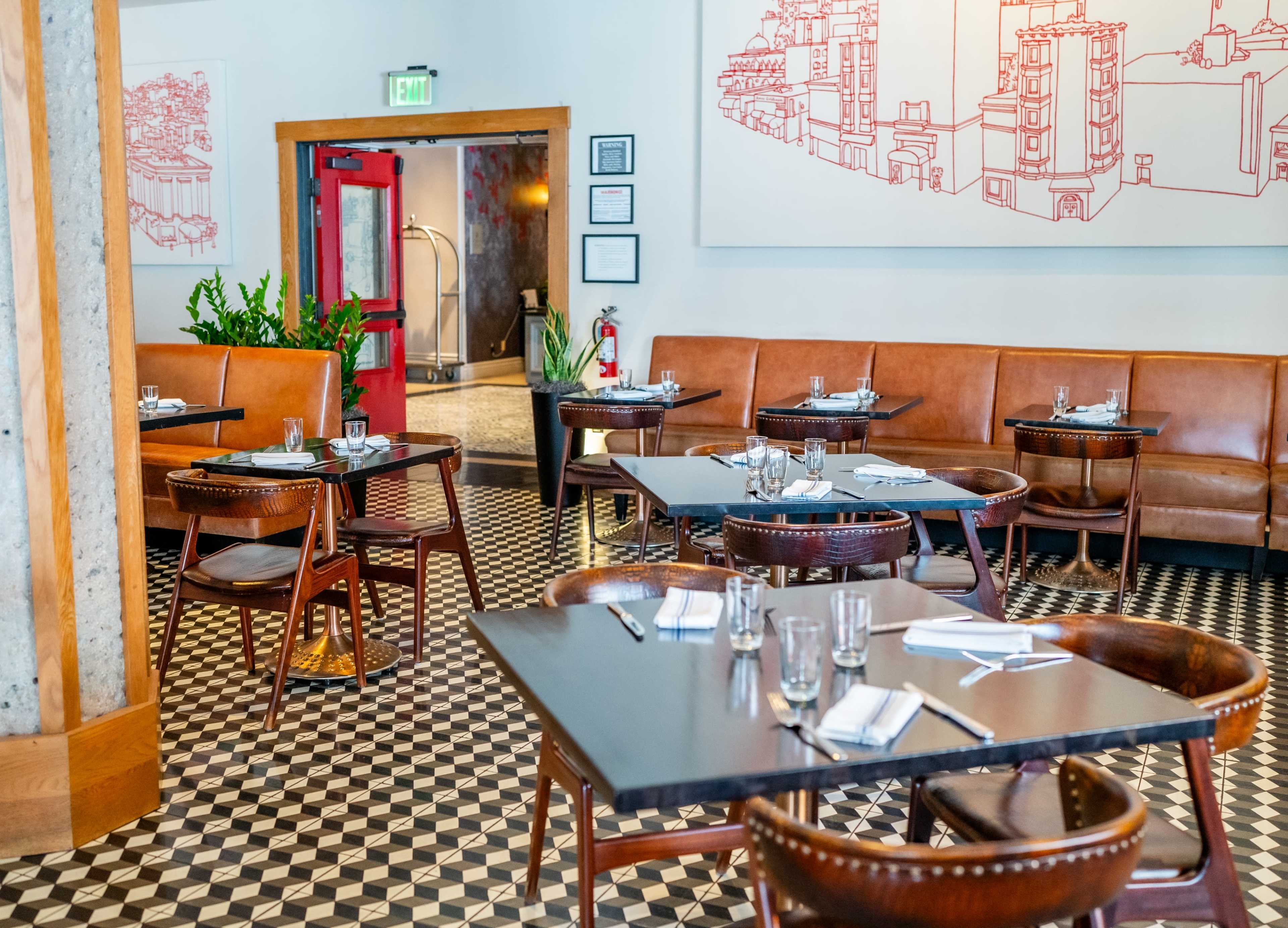 The image shows a modern restaurant interior with leather seating, wooden tables, and a patterned tile floor, featuring red decorative artwork on the walls.