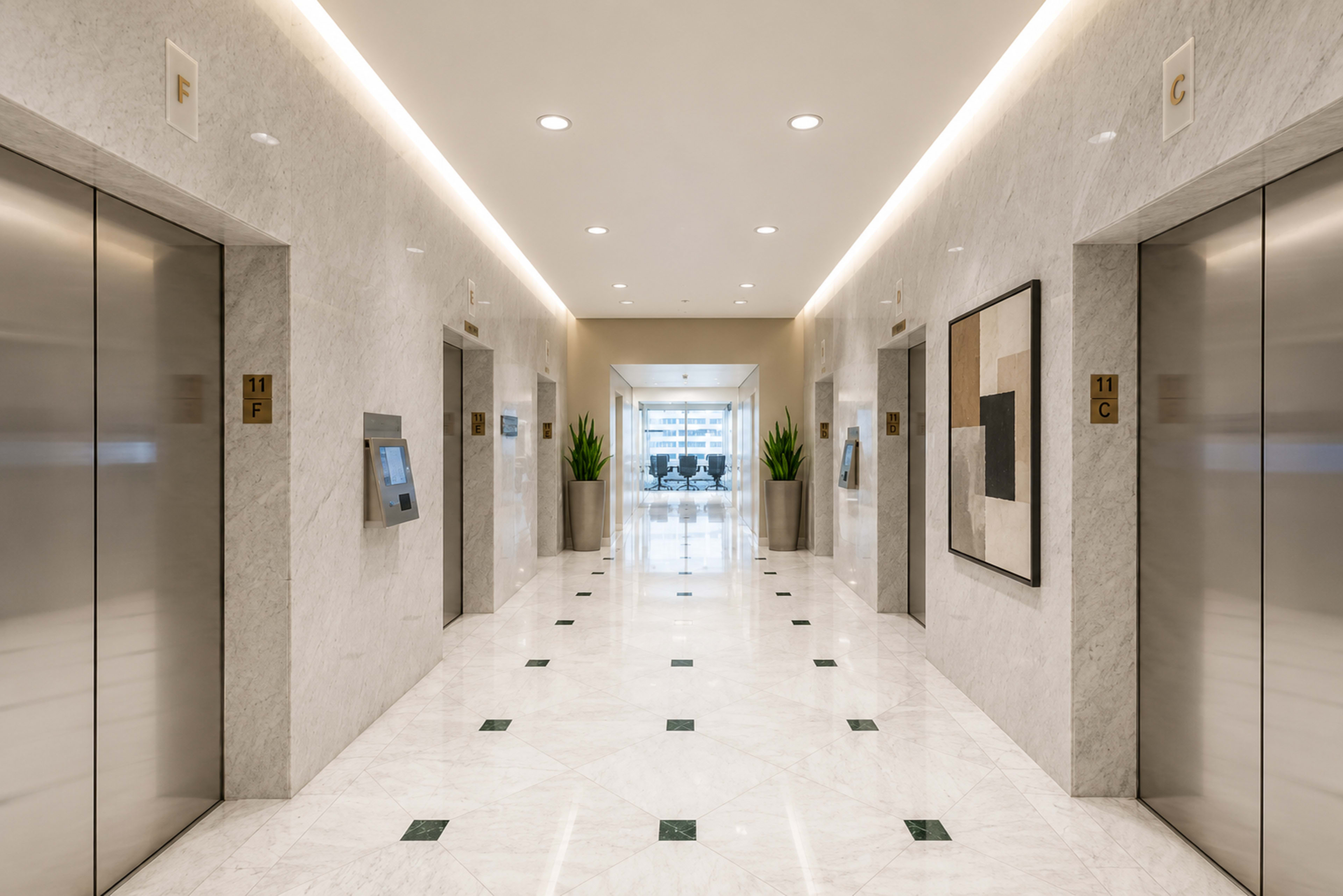 A modern, marble-floored hallway with elevator doors on each side and large windows at the end, featuring green plants and artwork on the walls.