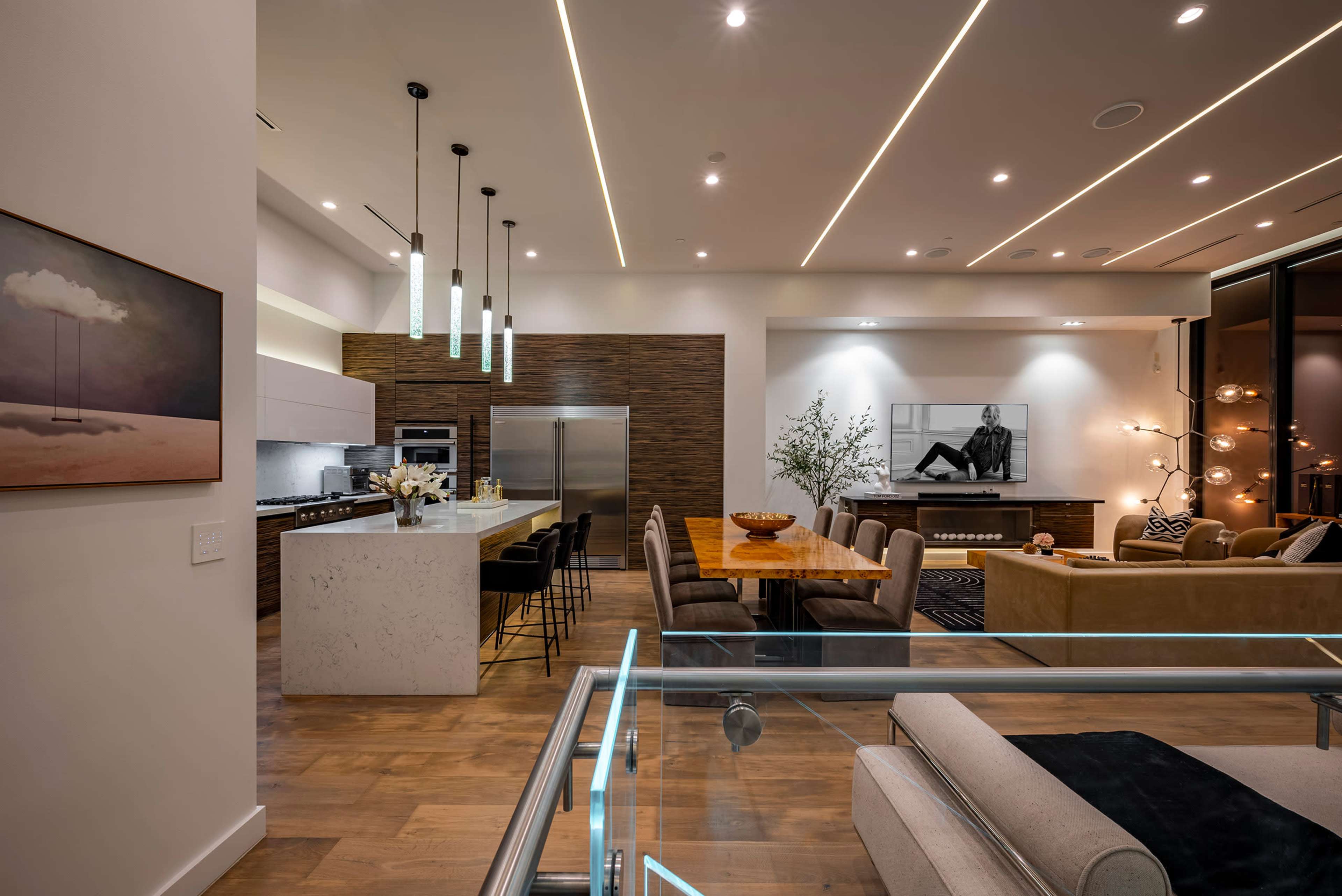 A modern open-concept living and dining area featuring a kitchen with a large island, a dining table, and a cozy seating arrangement.