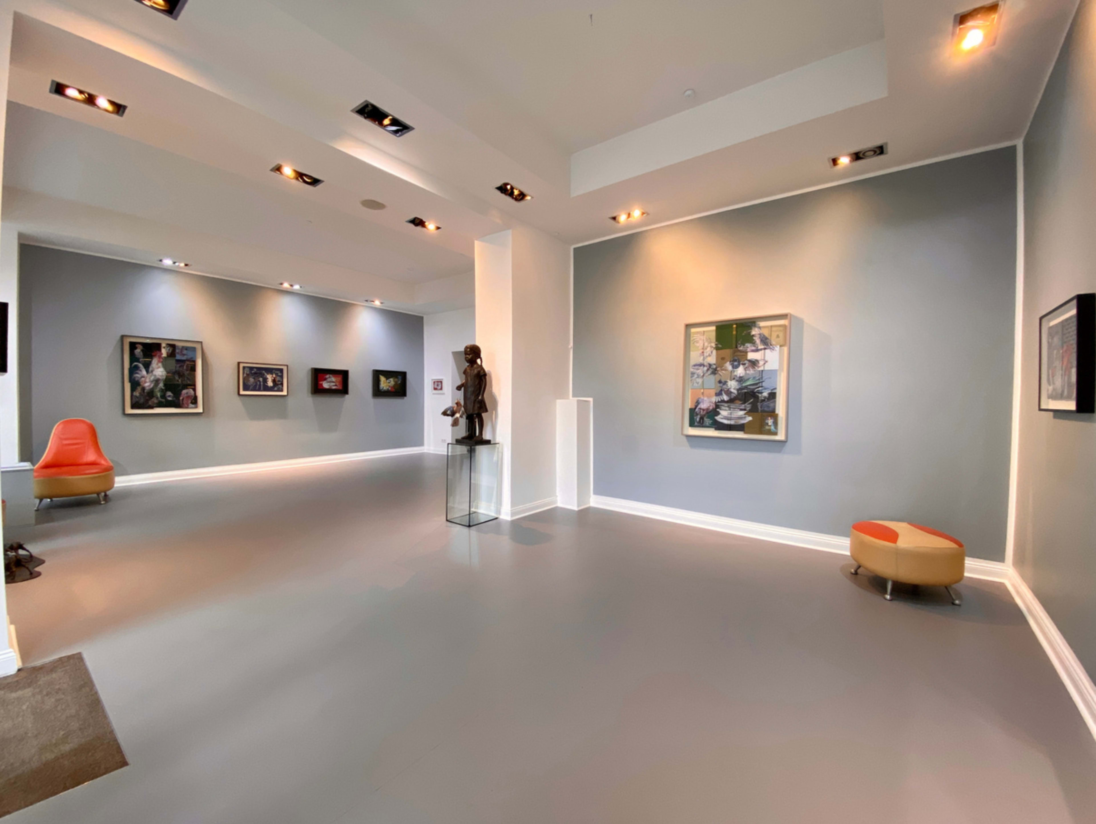 A modern gallery space with gray walls, three framed artworks, a sculpture on display, and contemporary seating.