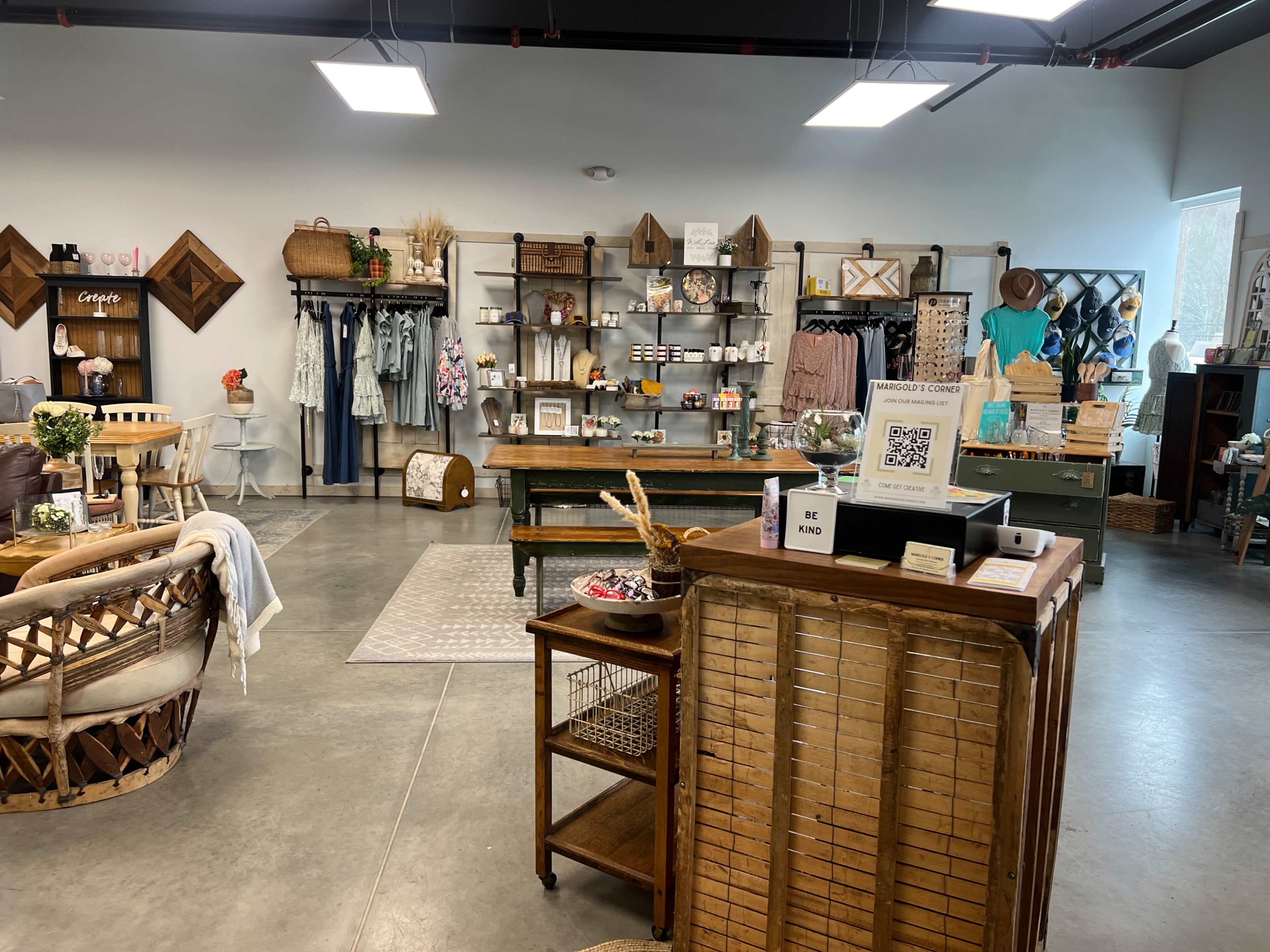A boutique interior with shelves displaying merchandise, seating areas, and a checkout counter made of wood.