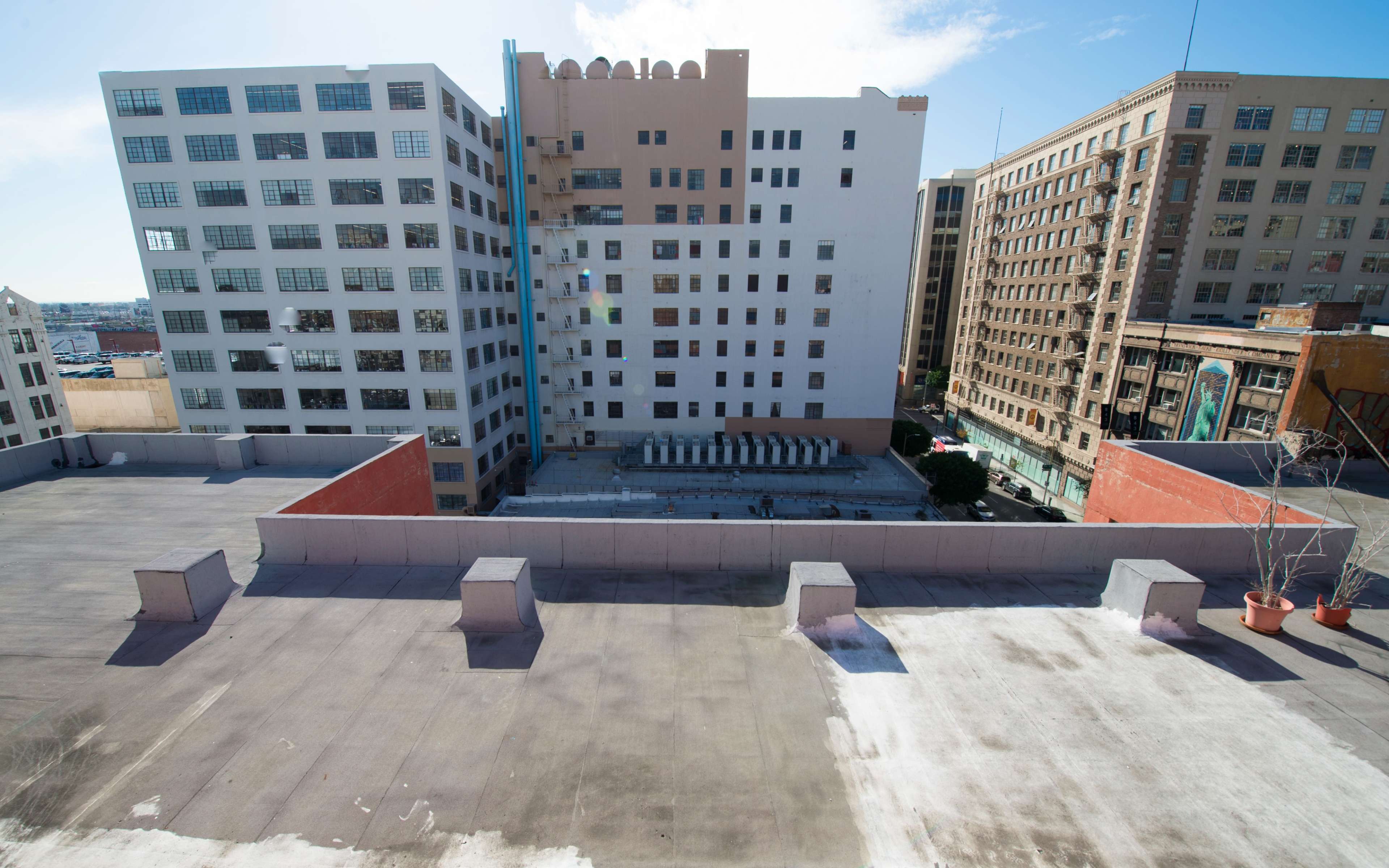 The image shows a rooftop view overlooking several multi-story buildings in an urban setting.