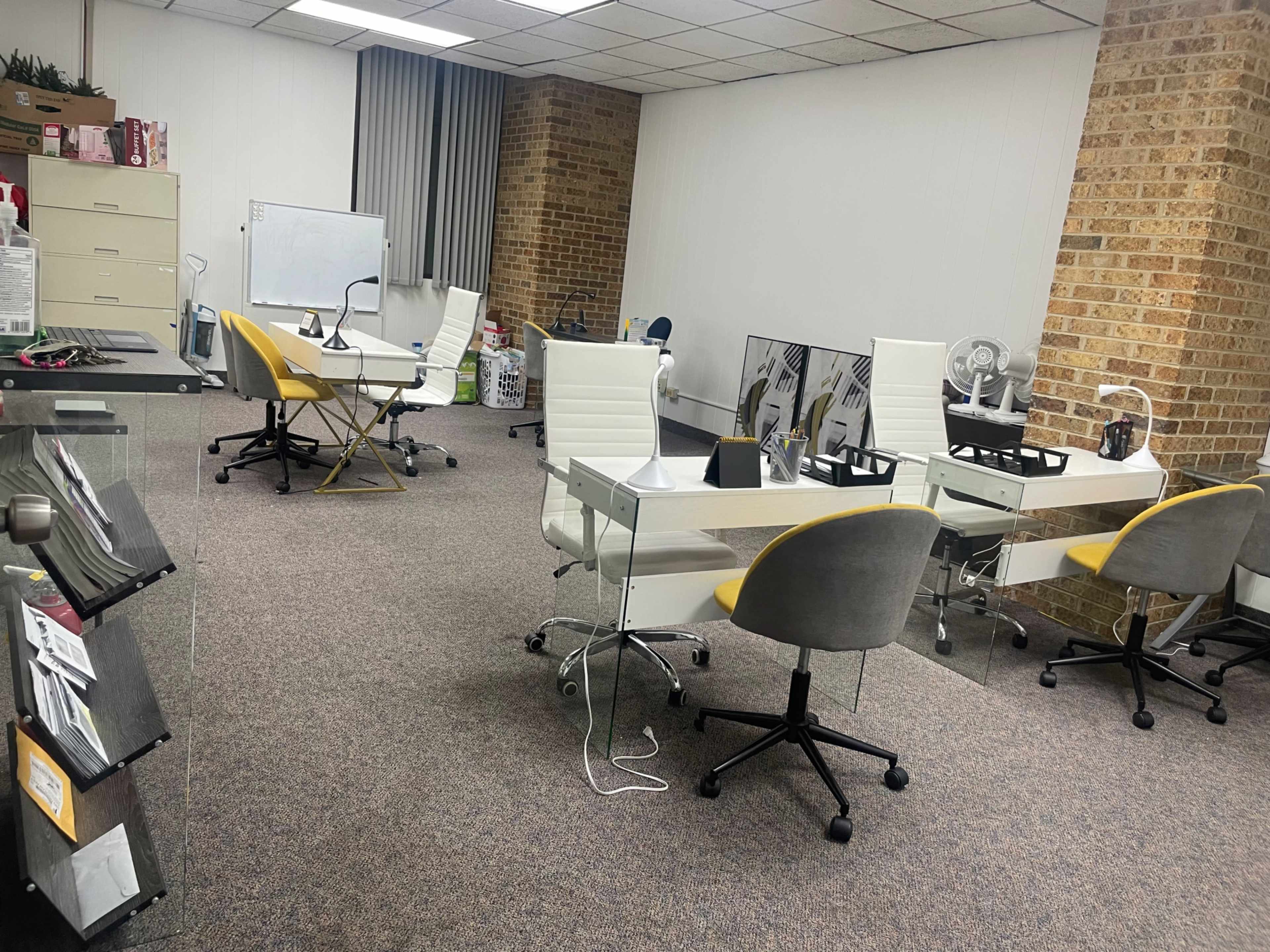 An office space with several desks and chairs arranged in a large, open area.