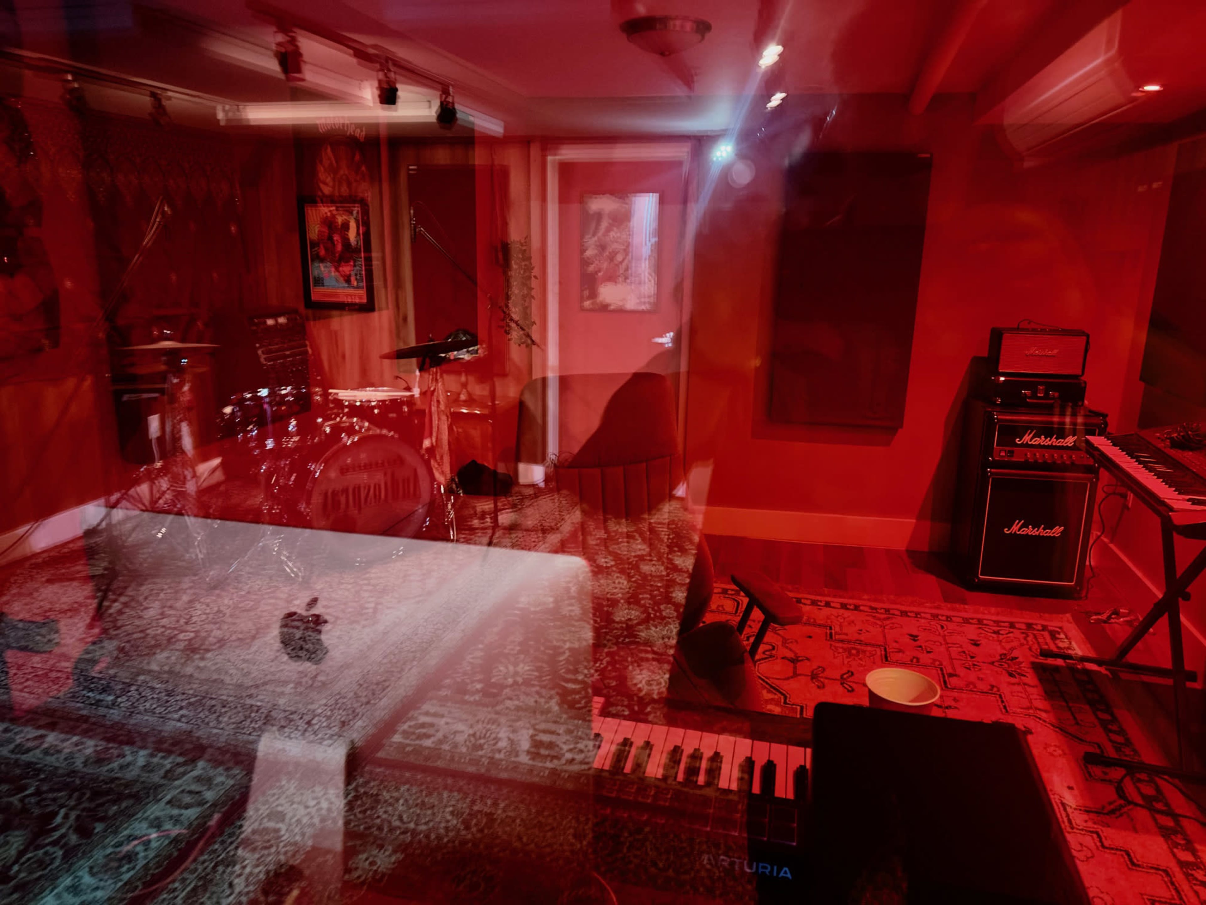 A music recording studio with various instruments and equipment arranged in a red-lit space.
