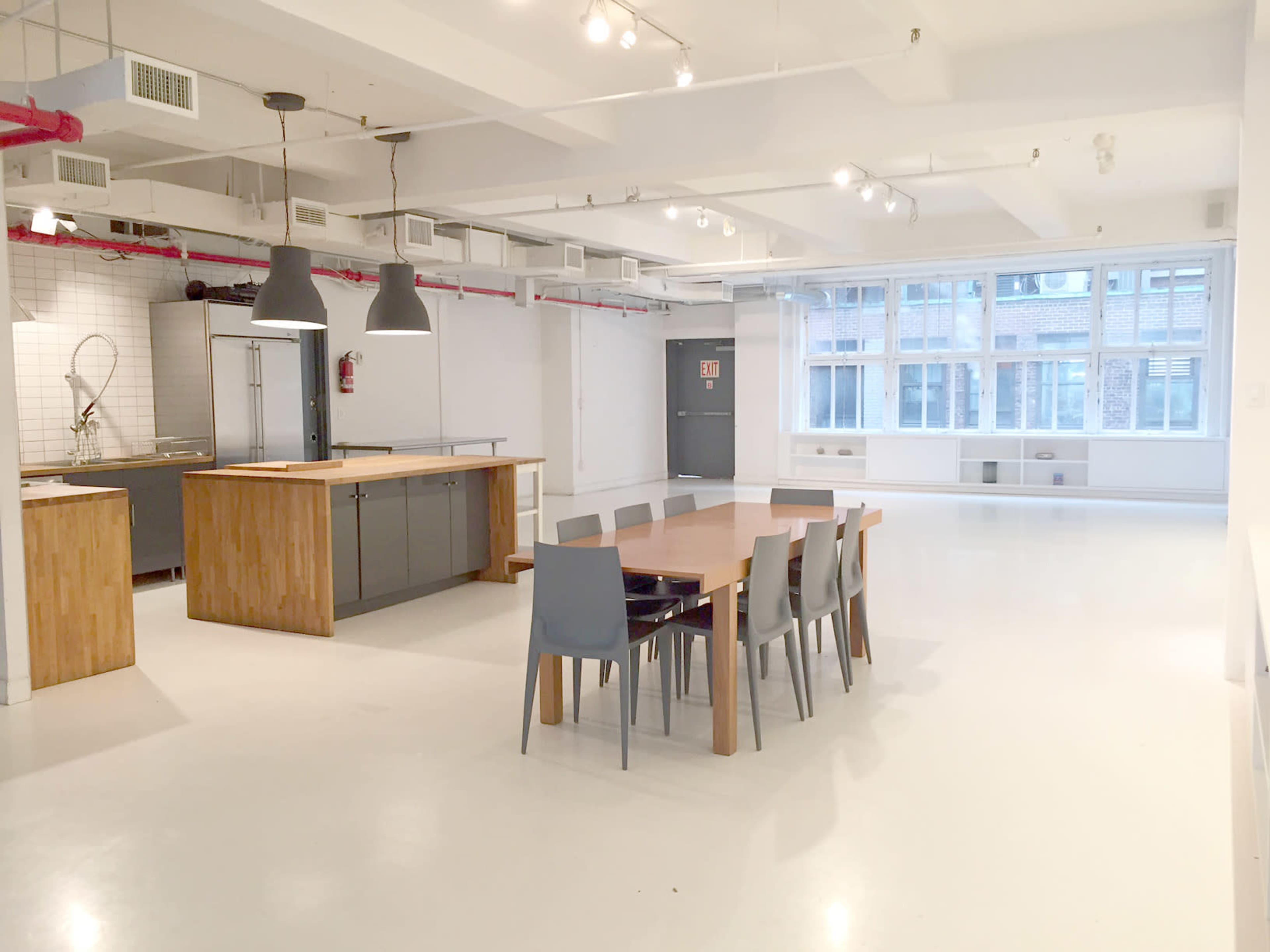 A modern, open kitchen and dining area with a large table surrounded by chairs and a minimalist design.