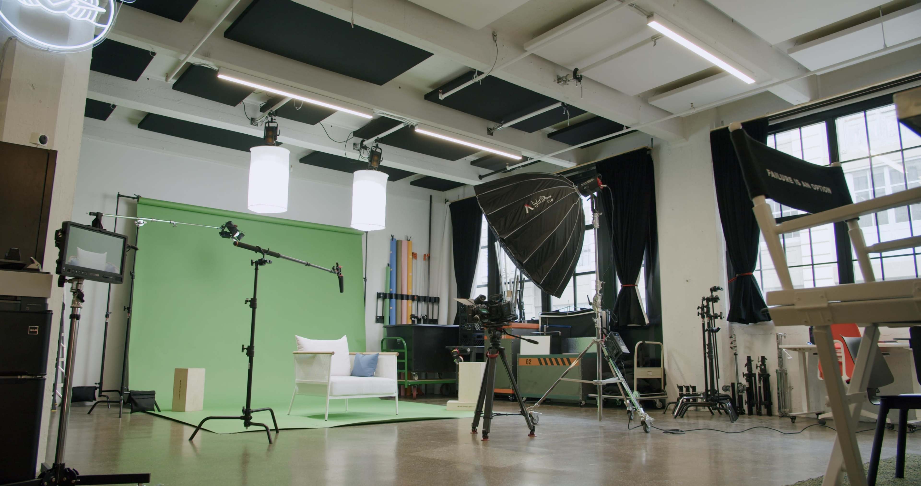 A well-lit studio setup featuring a green screen, photography equipment, and various props arranged for a shoot.