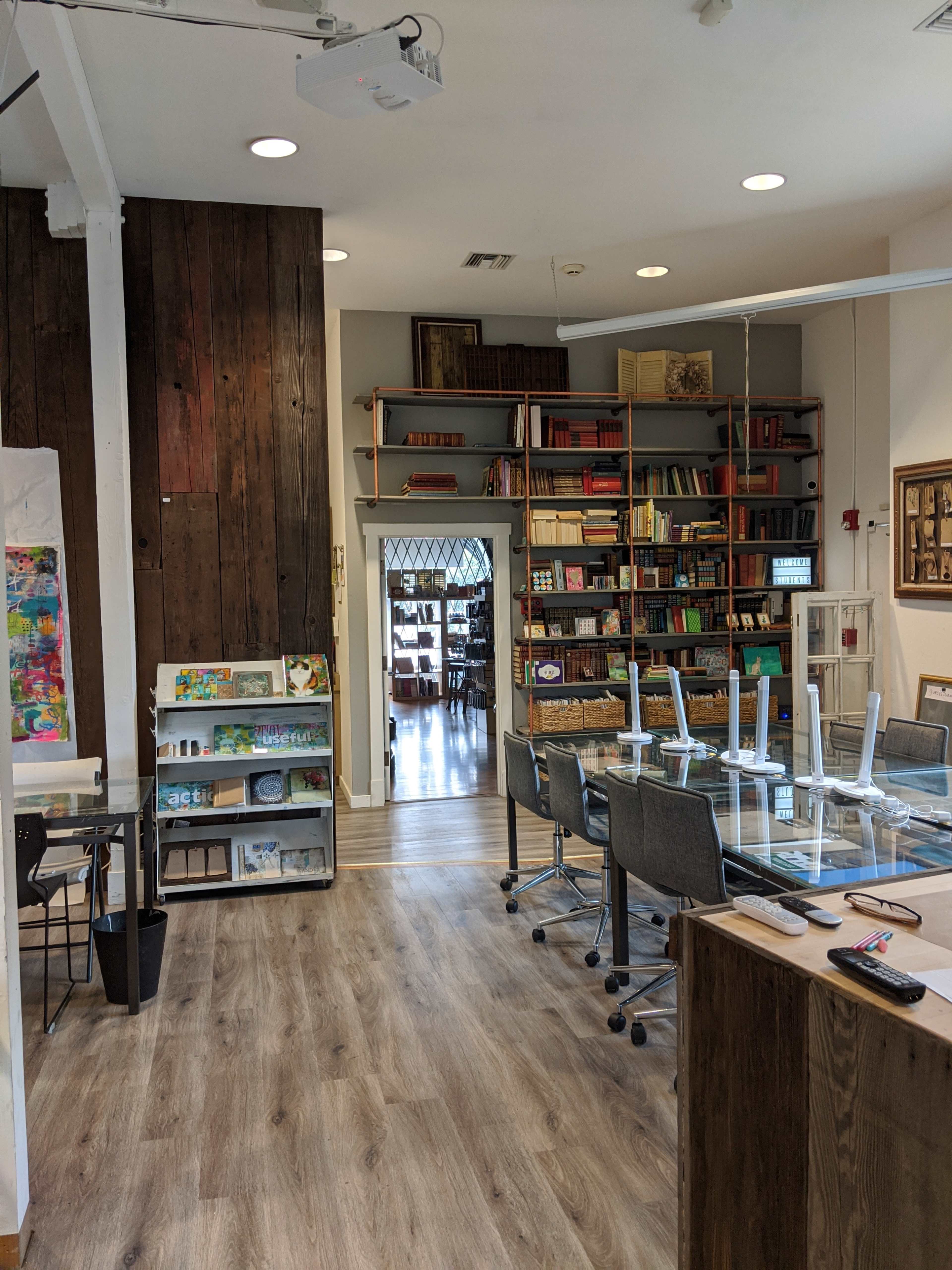 A well-organized interior space with bookshelves, a table with chairs, and wooden accents.
